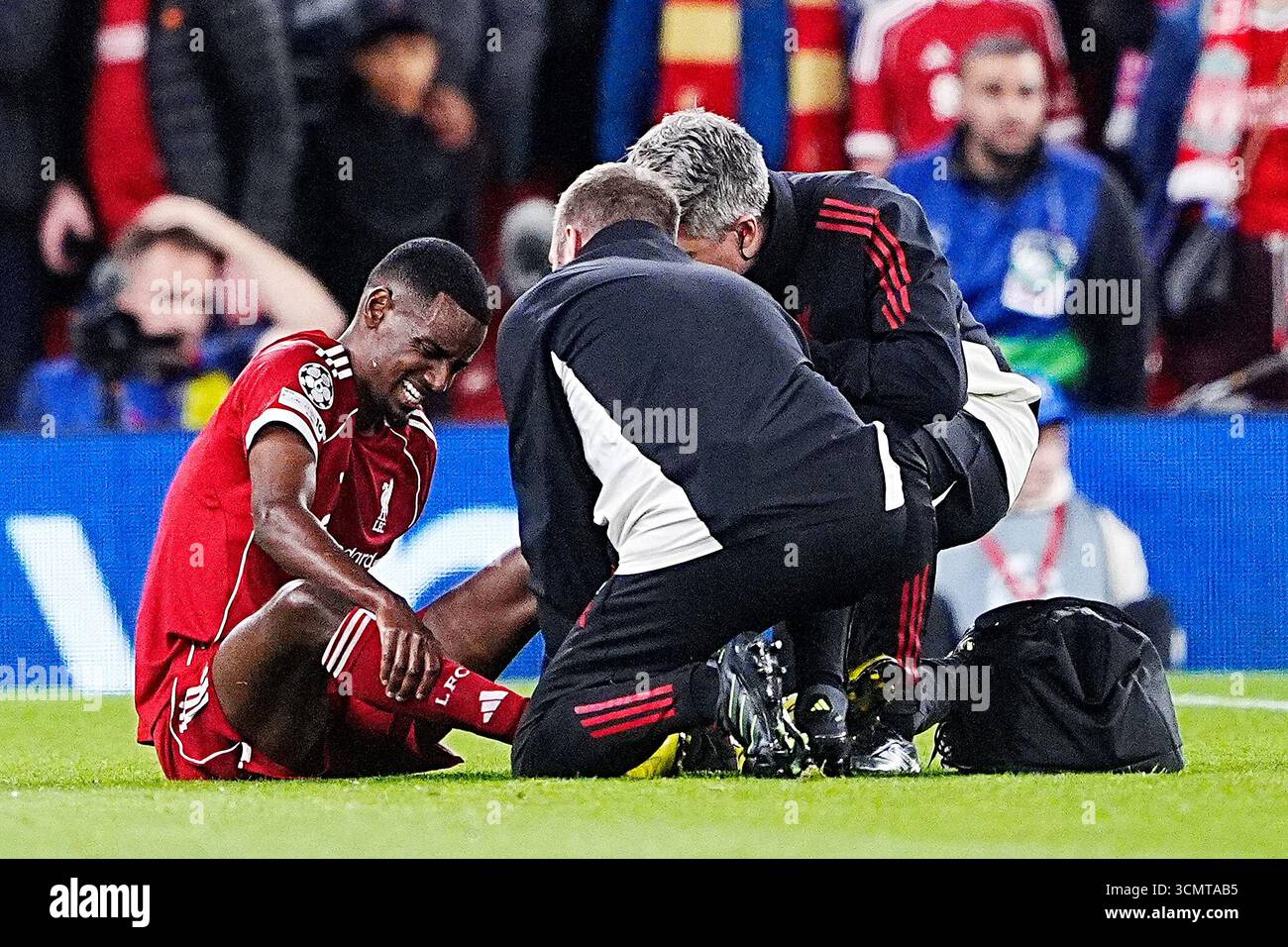 Liverpool's Alexander Isak is treated by medical staff after going down ...