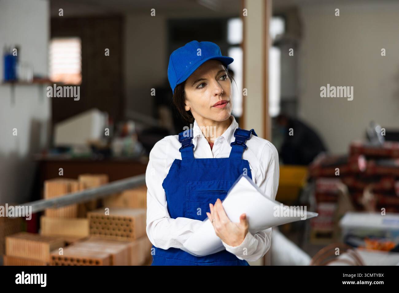Female designer making checklist while planning building overhaul Stock Photo