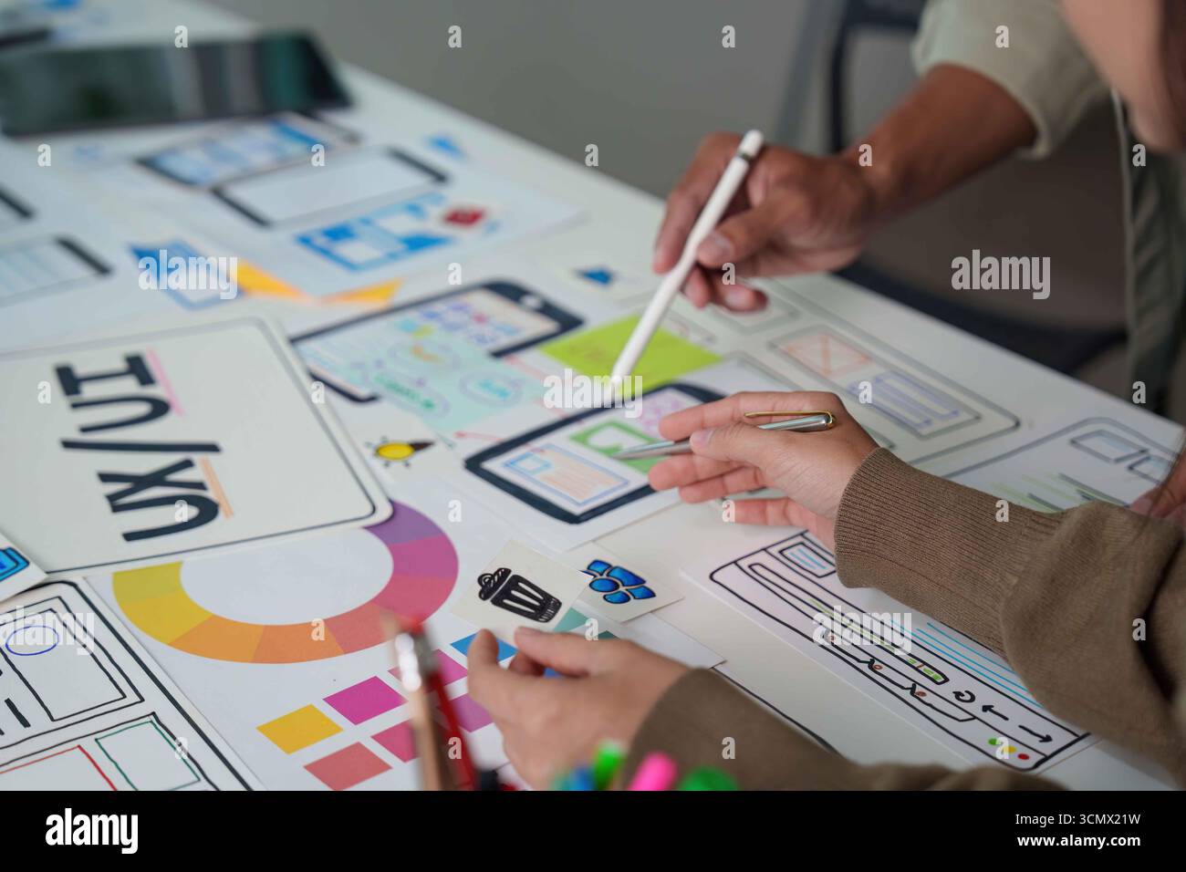 Collaborative UX UI Design. Team Members Working on Mobile App Wireframes and User Interfaces. Stock Photo