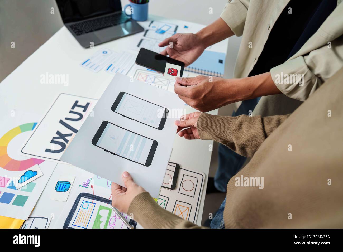 UX UI Prototyping Session. Team creating mobile interface designs and discussing concepts. Stock Photo