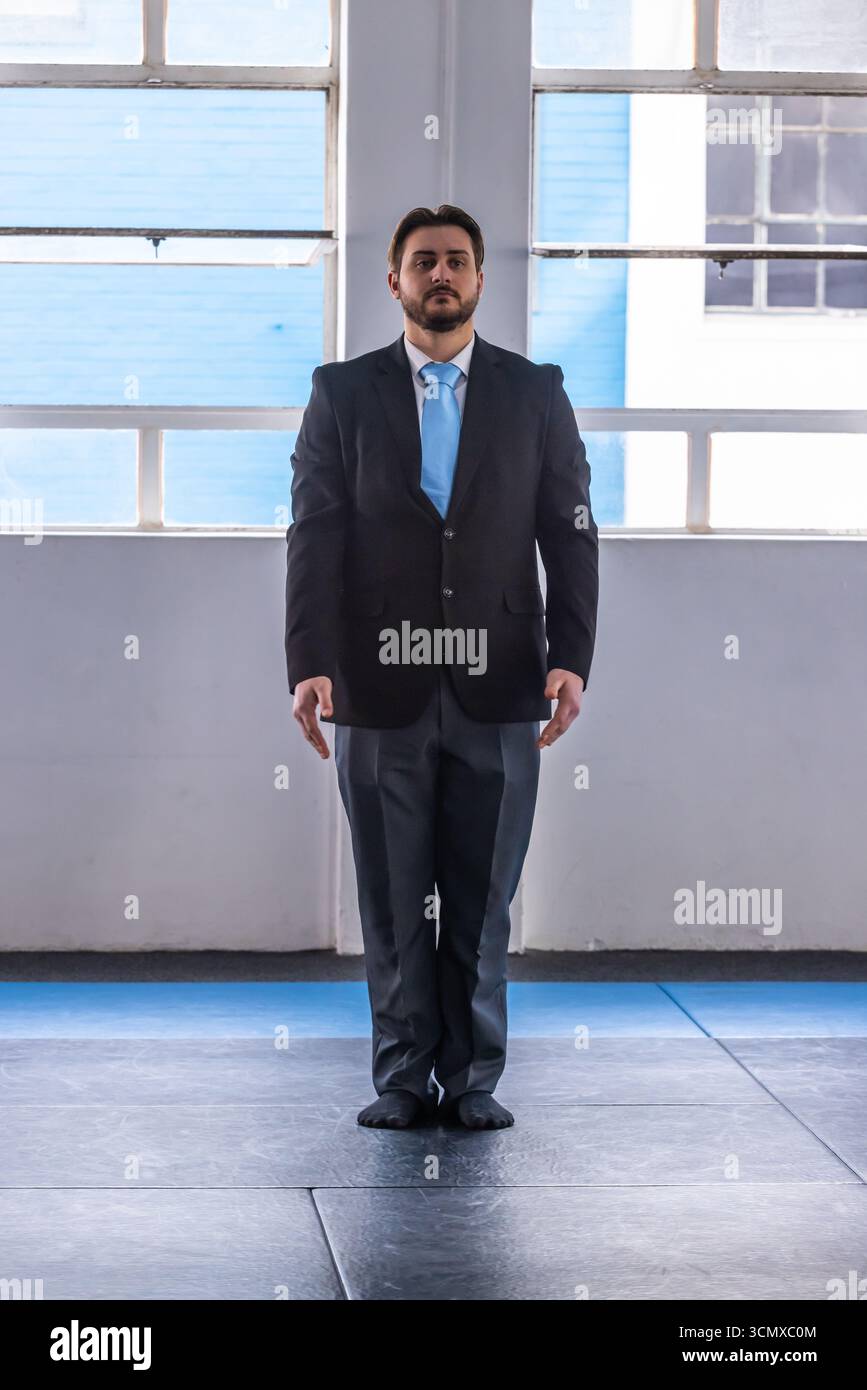 Male standing on mats under metal framed windows in training hall ...