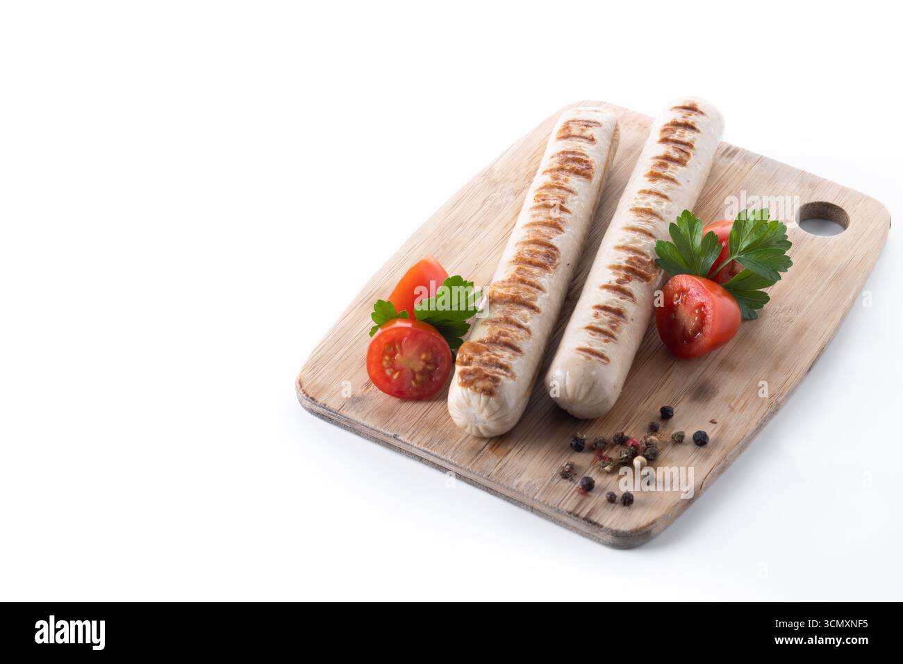Grilled Bratwurst sausages with cherry tomatoes and parsley isolated on white background Stock Photo