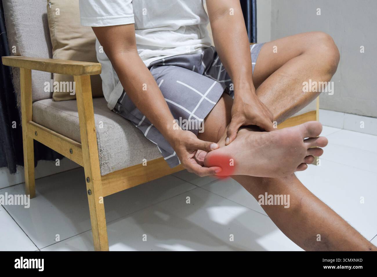 foot pain, young man suffering from feet ache in home, podiatry concept Stock Photo