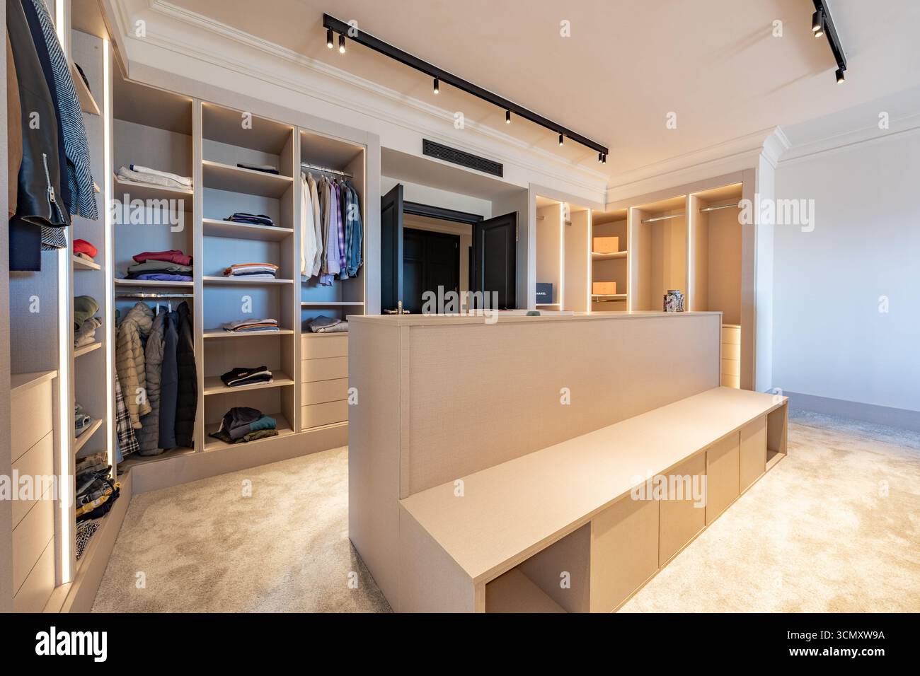 Walk In Robe Seating an image of a luxury walk in wardrobe with wooden seating bench in ...