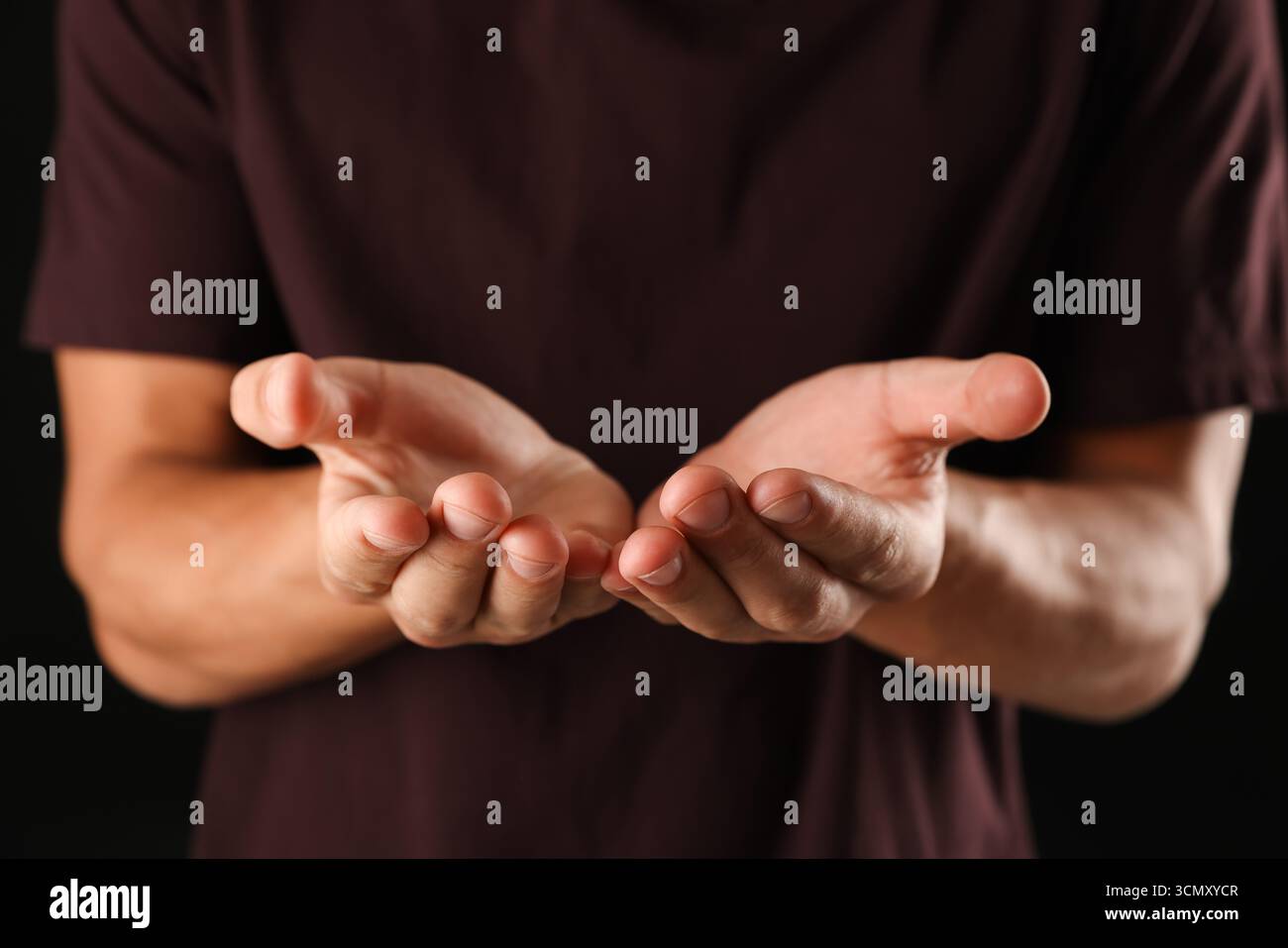Man holding something on black background, closeup Stock Photo