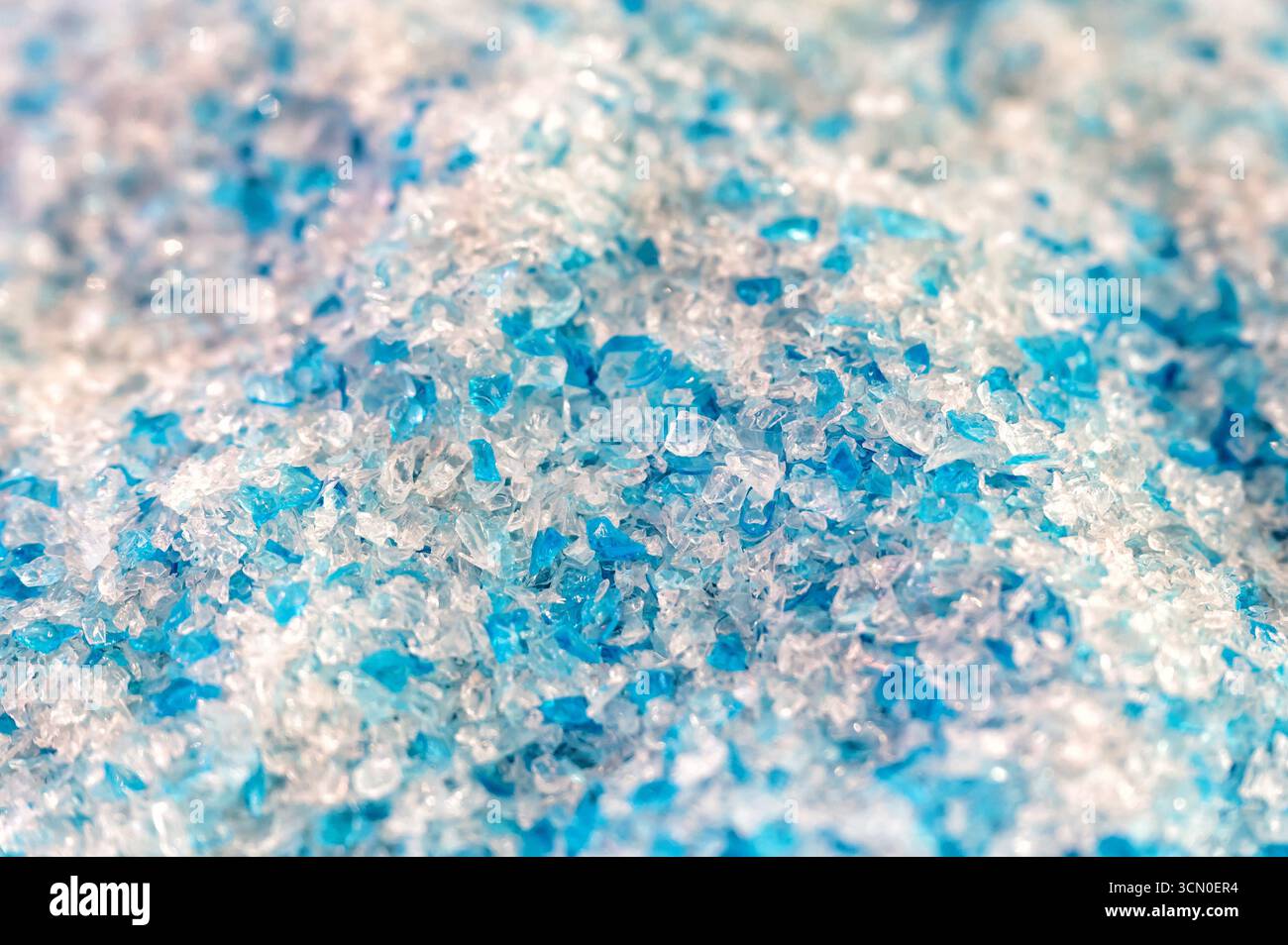 Small pieces of plastic create a colorful and textured background, ideal for industrial or recycling themes Stock Photo