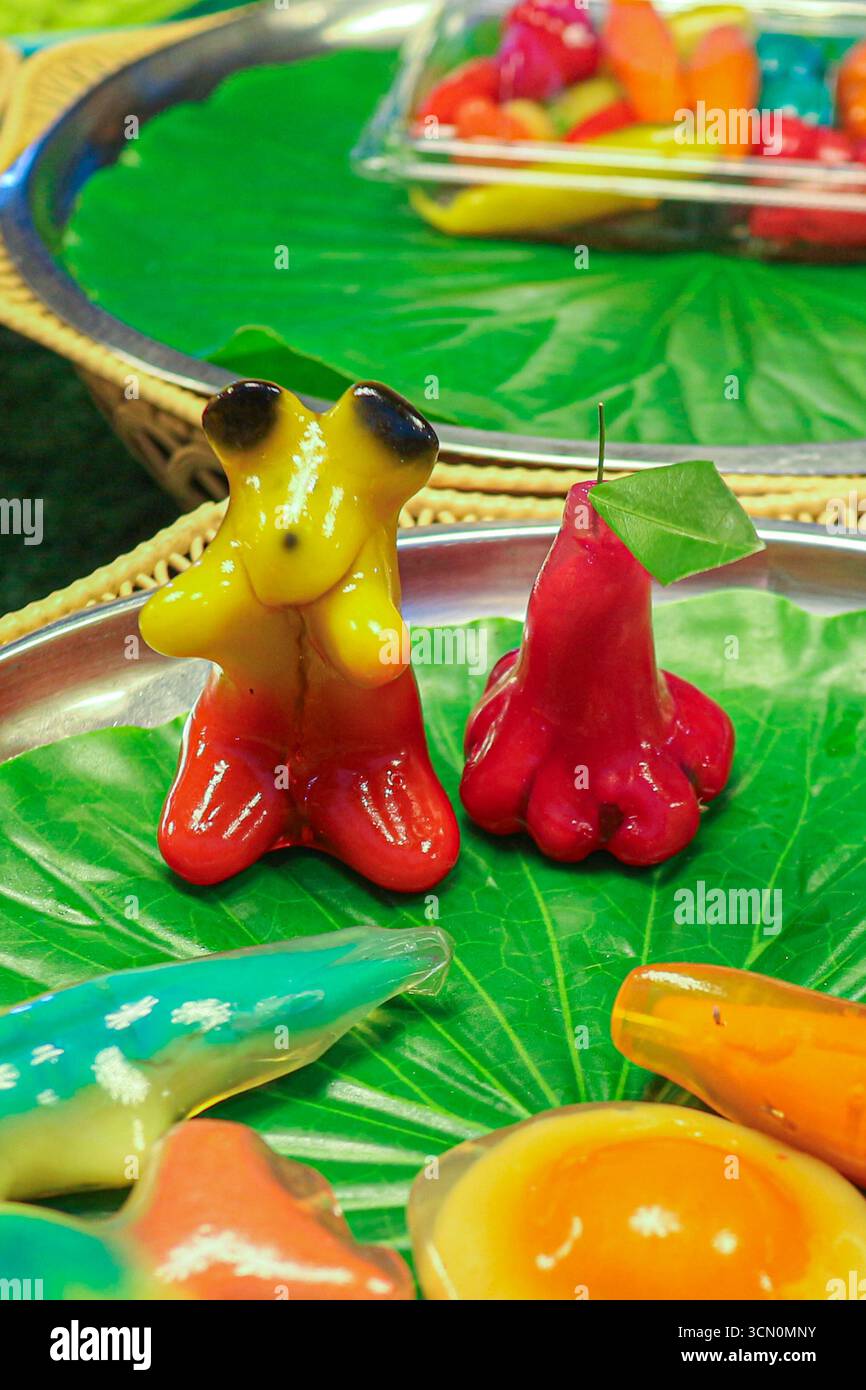 Thai luk chup mung bean desserts shaped as bear and rose apple with vibrant colors, glossy gelatin glaze, and traditional artistic detail. Stock Photo