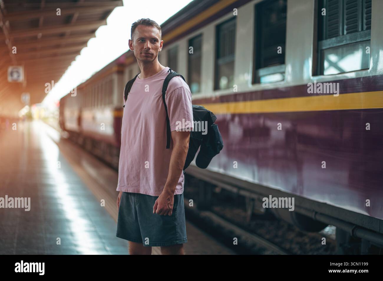 traveler guy boarding train at busy railroad station, young man with ...