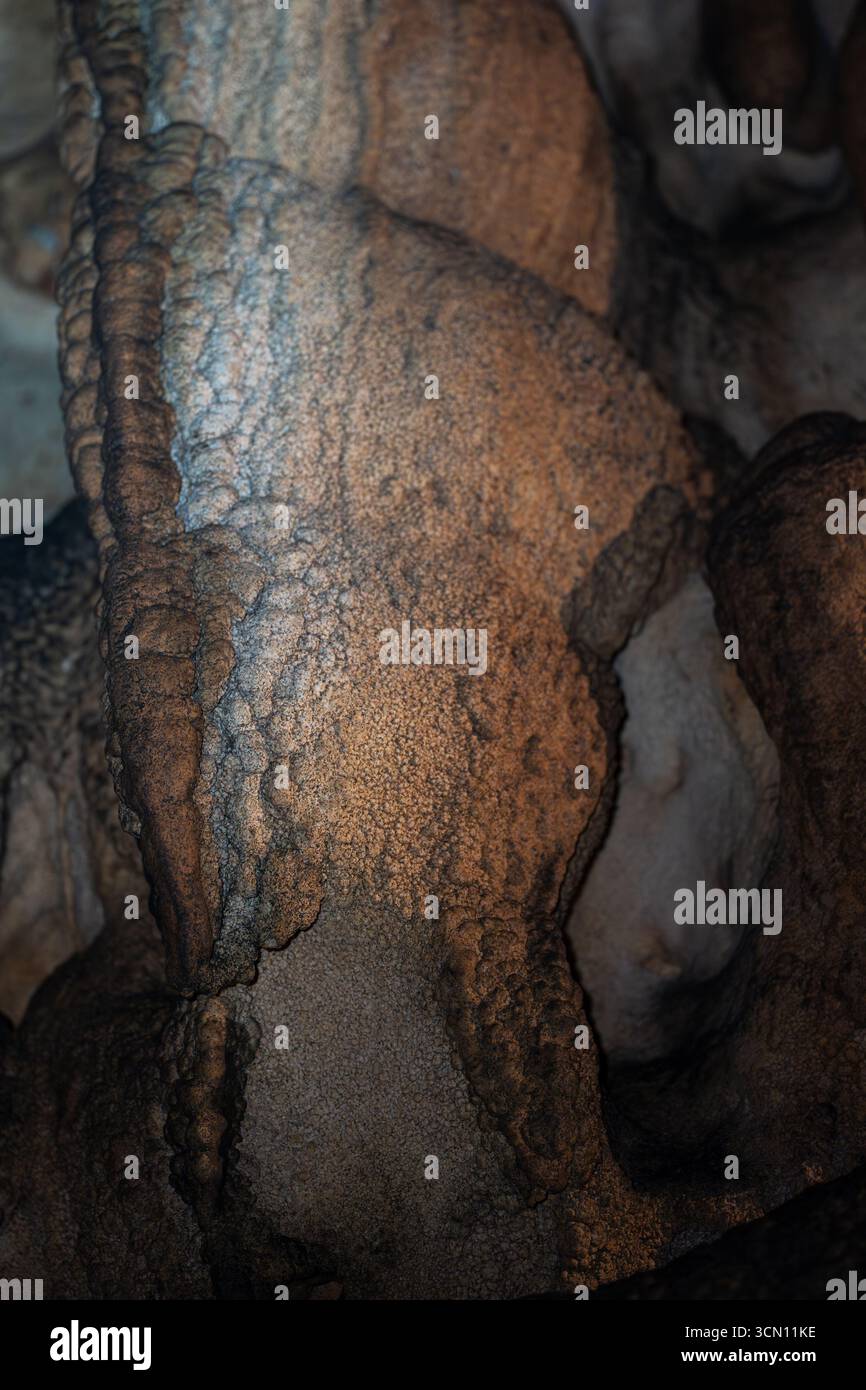 Large flowstone structure inside a limestone cave illuminated by warm ...