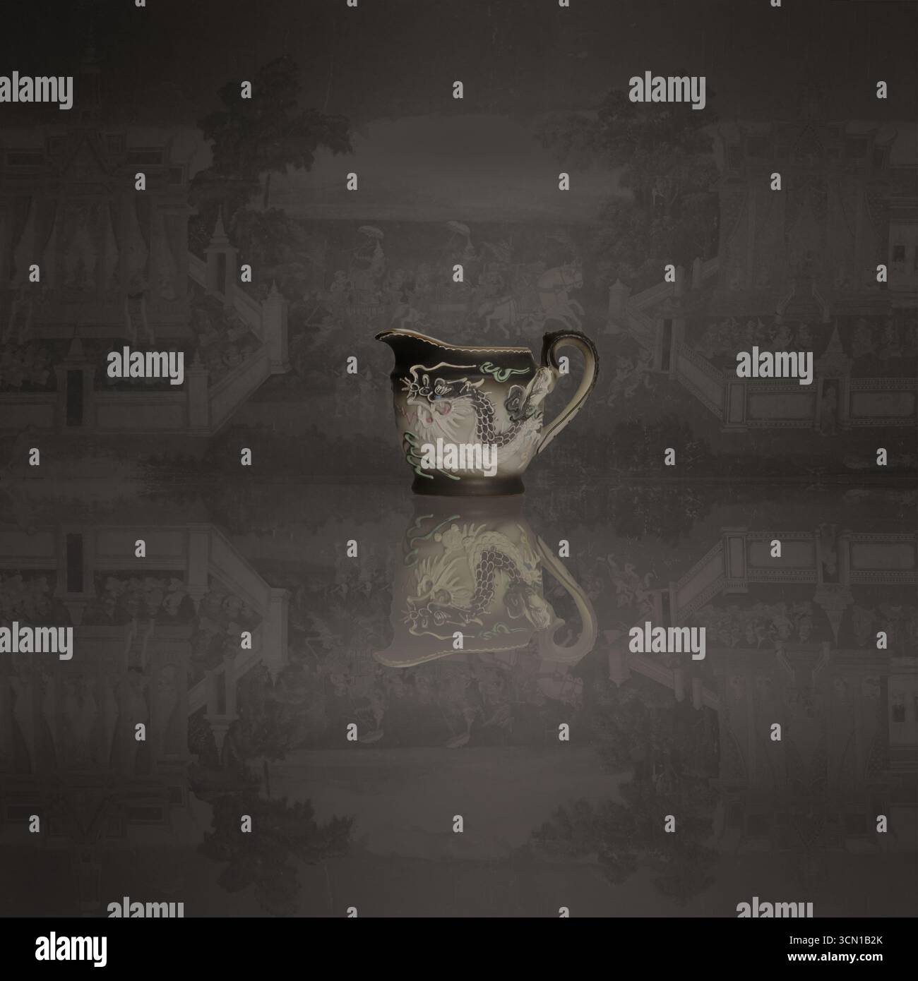 Antique porcelain milk jug with dragon motif design and reflection Stock Photo