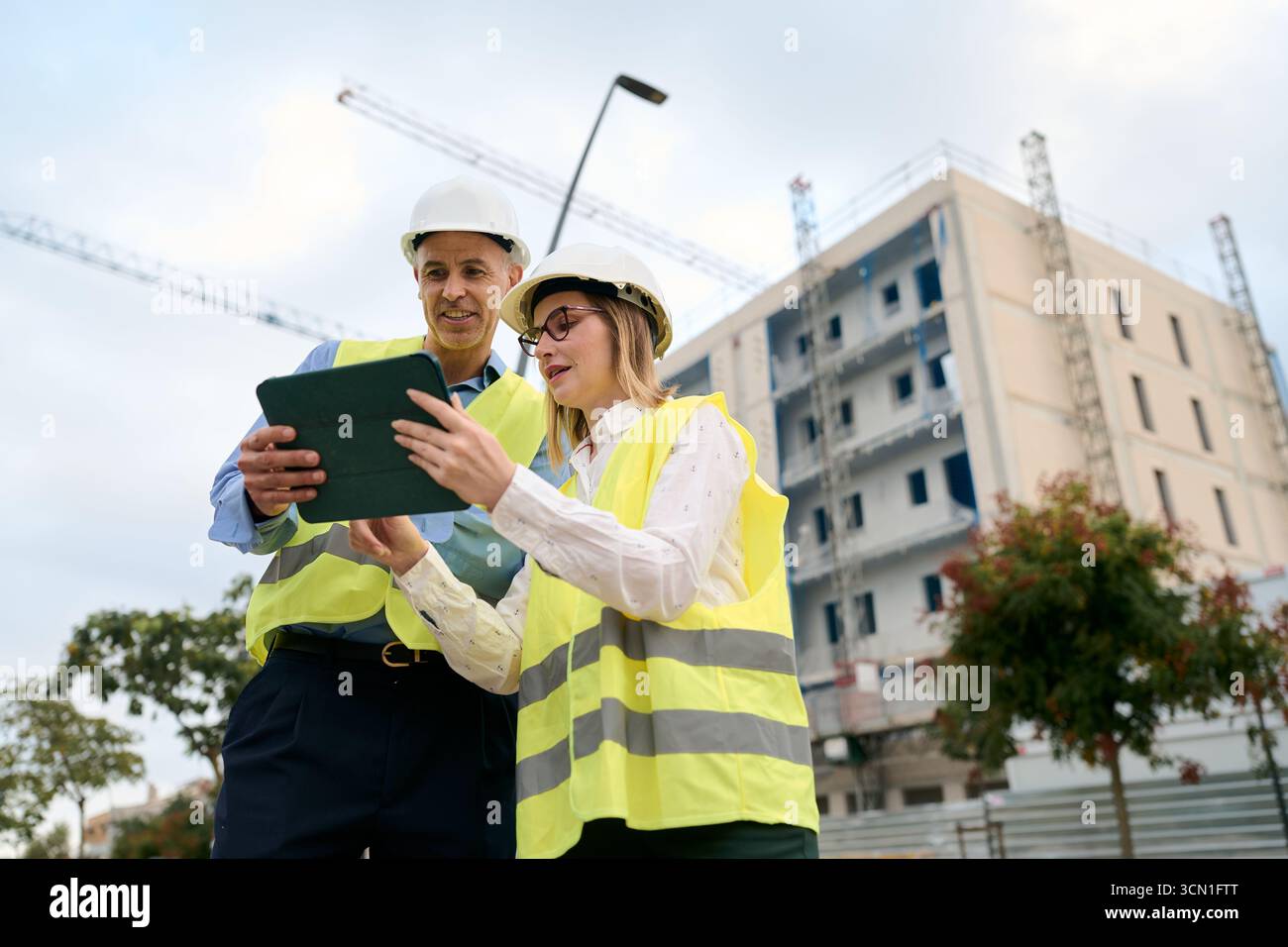 Engineers collaborating on construction site using tablet Stock Photo