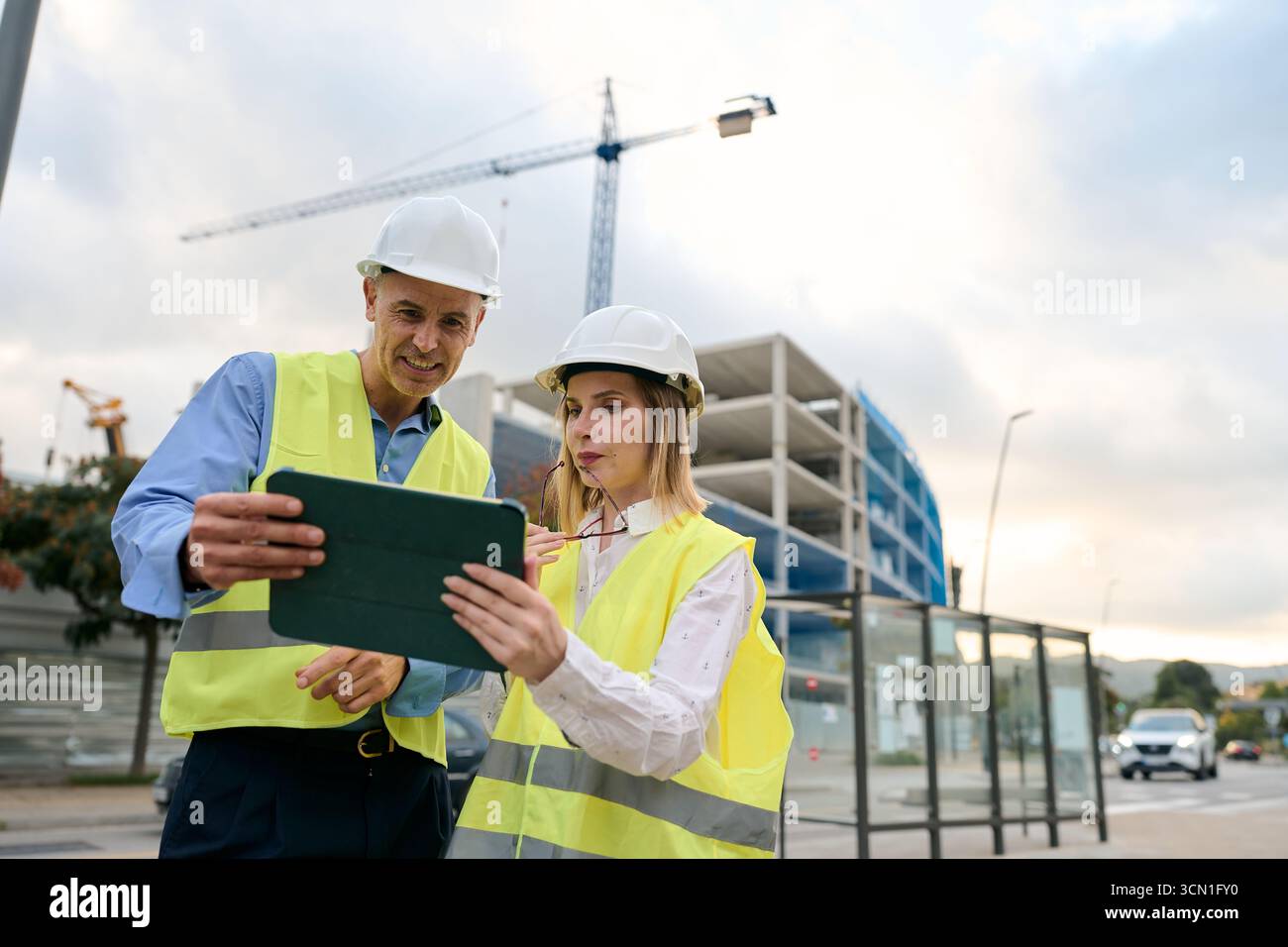 Engineers discussing construction project plans using tablet Stock Photo