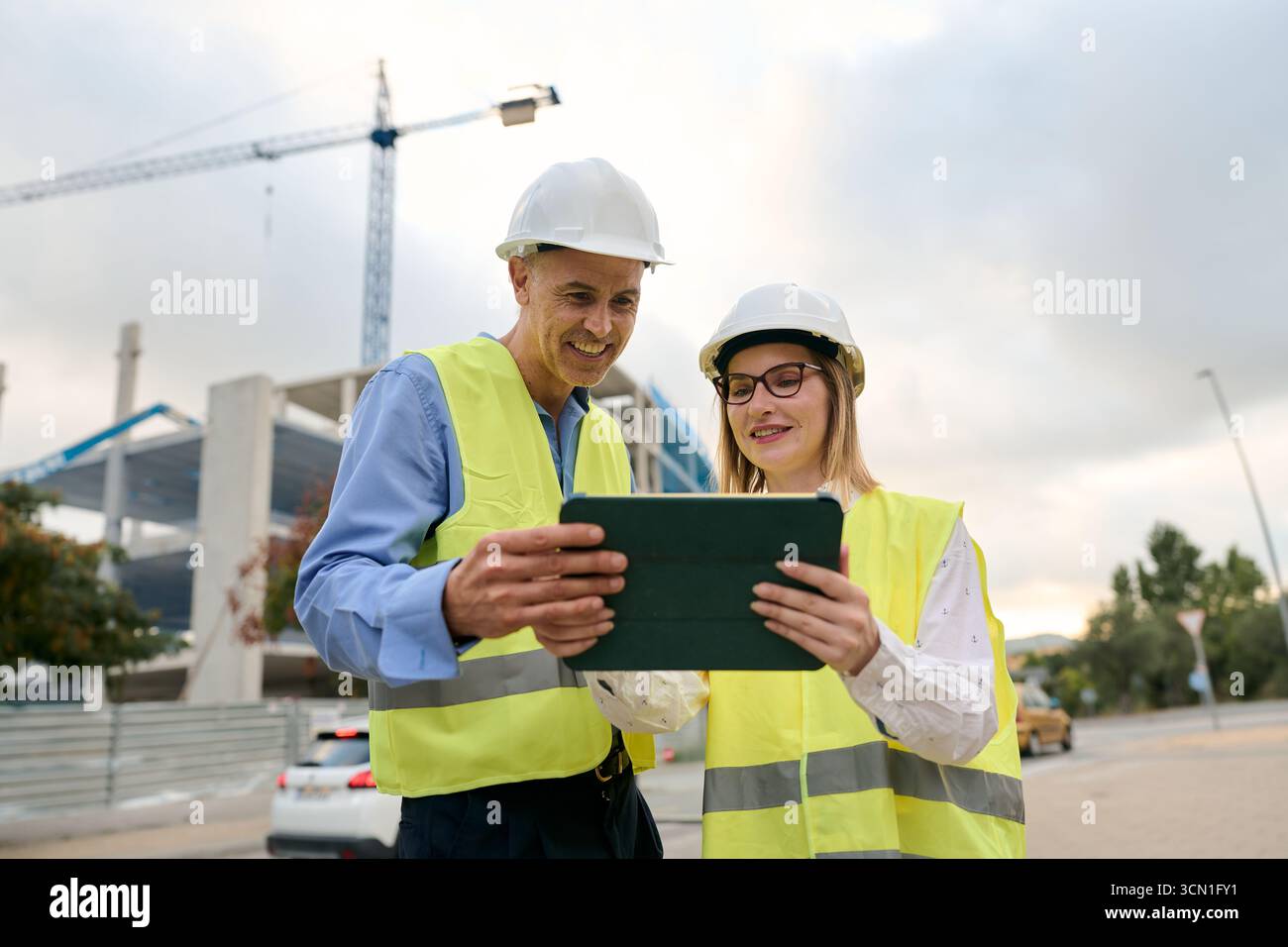 Engineers discussing construction plans using digital tablet Stock Photo