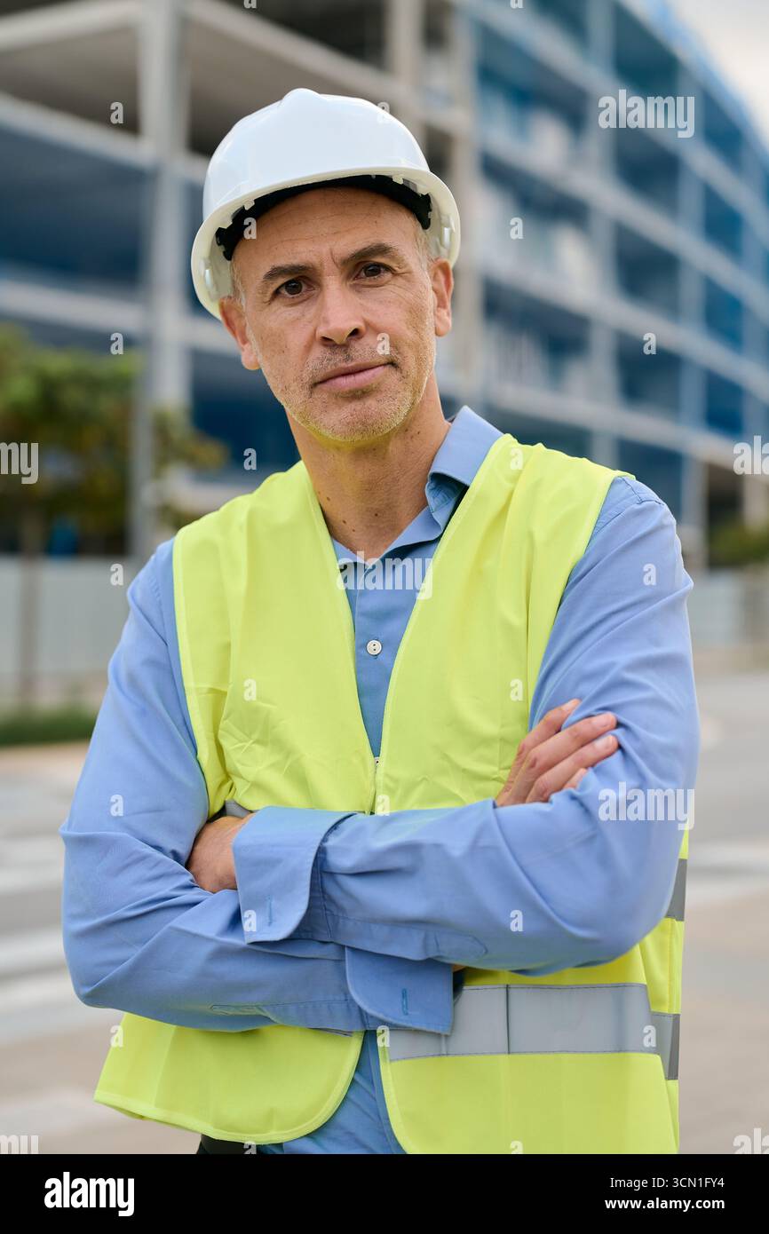 Construction engineer wearing hard hat standing at building site Stock Photo