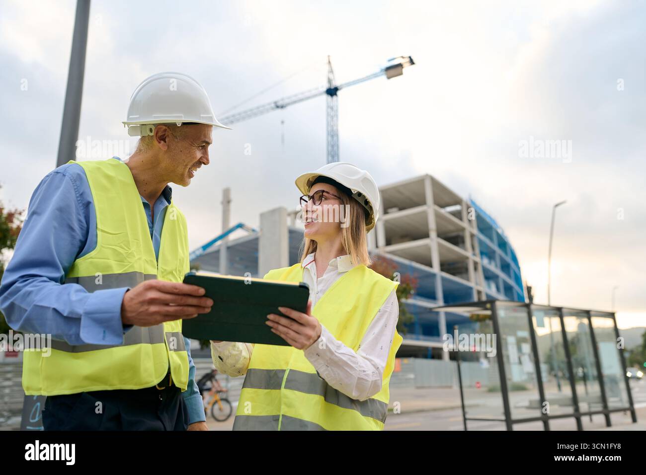 Engineers discussing building plans using digital tablet Stock Photo