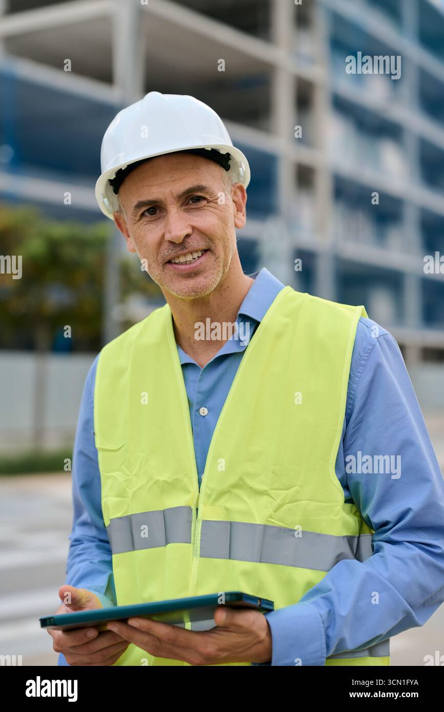 Construction engineer managing building project with digital tablet Stock Photo