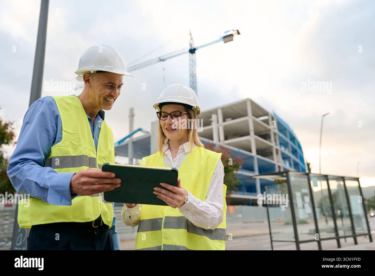 Construction engineers working on site discussing building plans Stock Photo