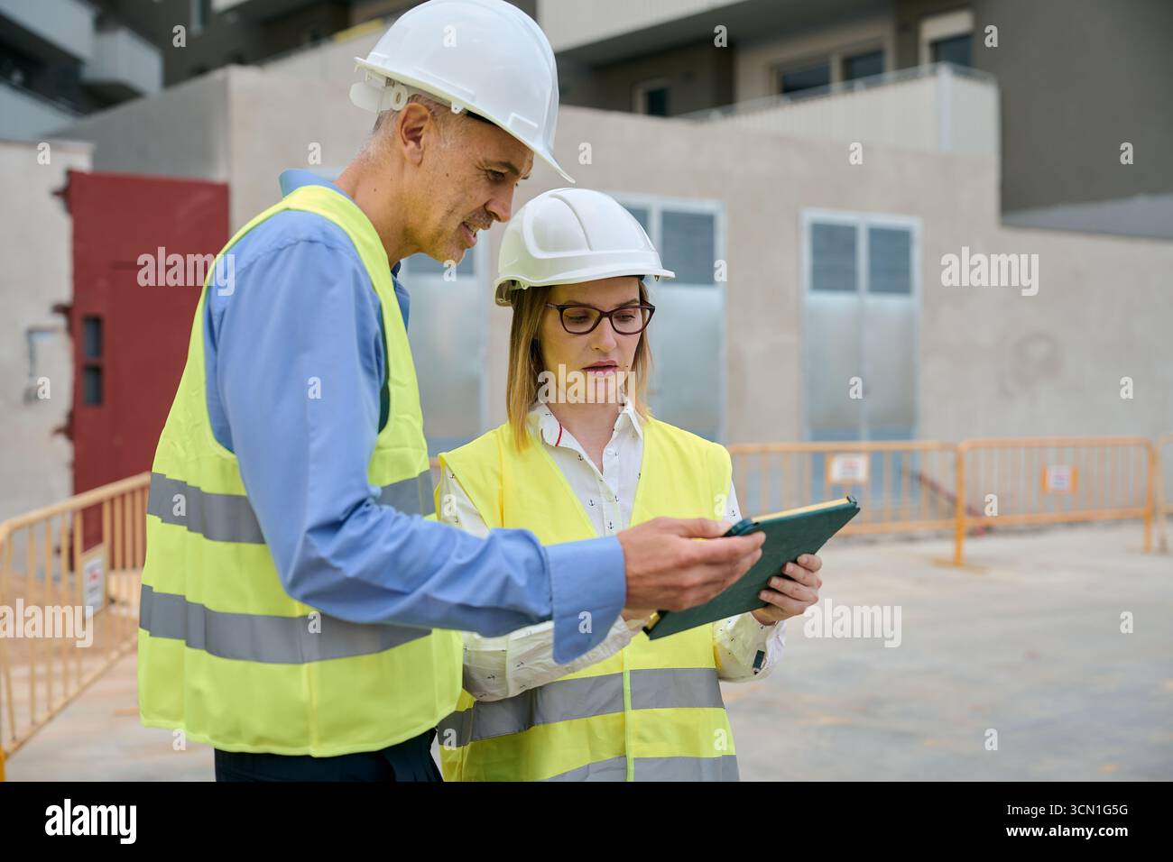 Construction engineers planning project details using tablet Stock Photo