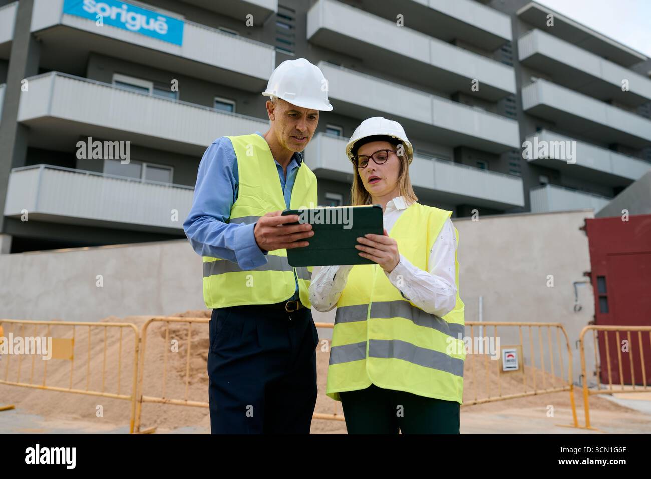 Engineers collaborating on construction site using tablet Stock Photo