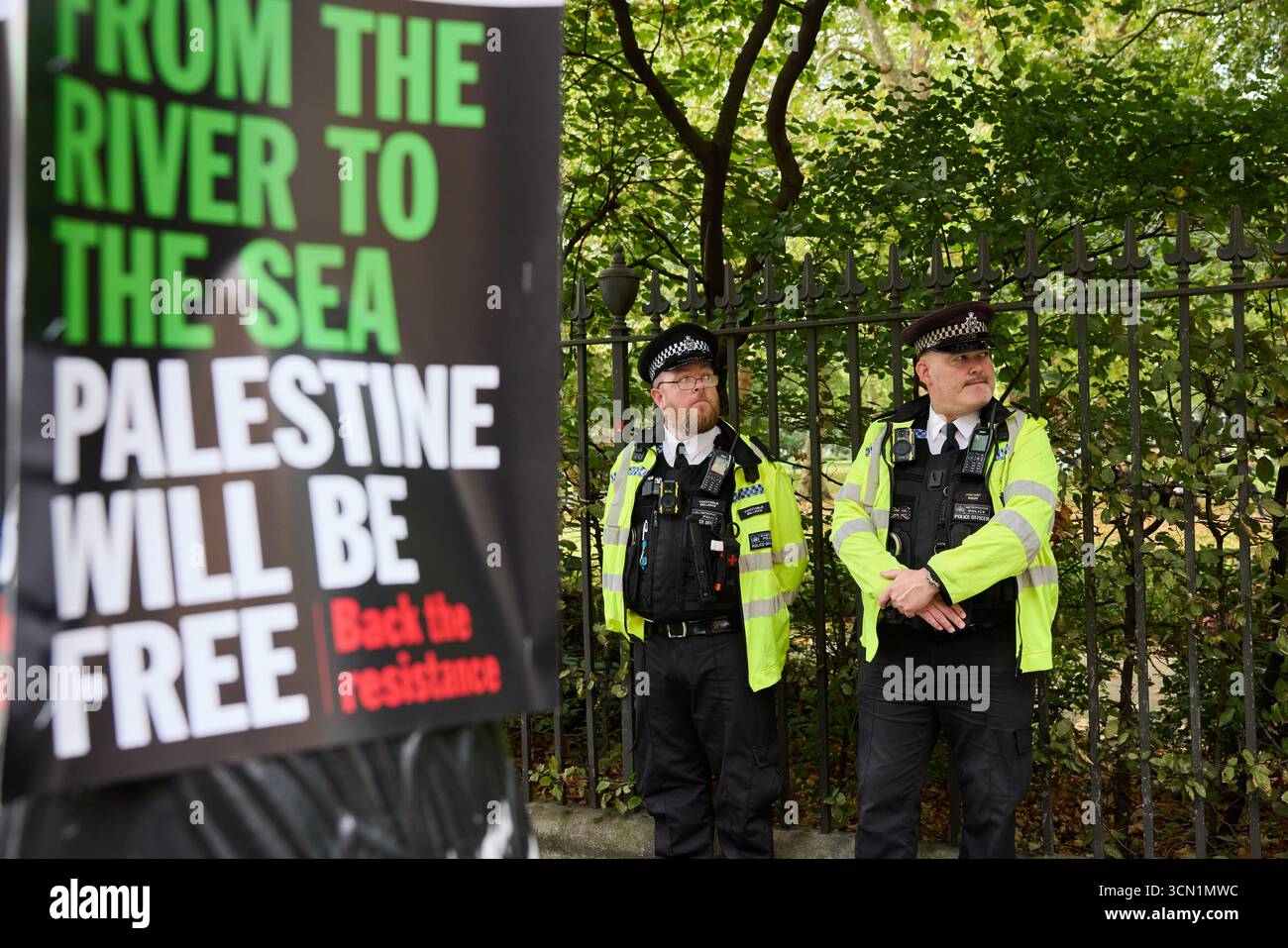 Metropolitan police officers walking passed pro palestine signs Stock ...