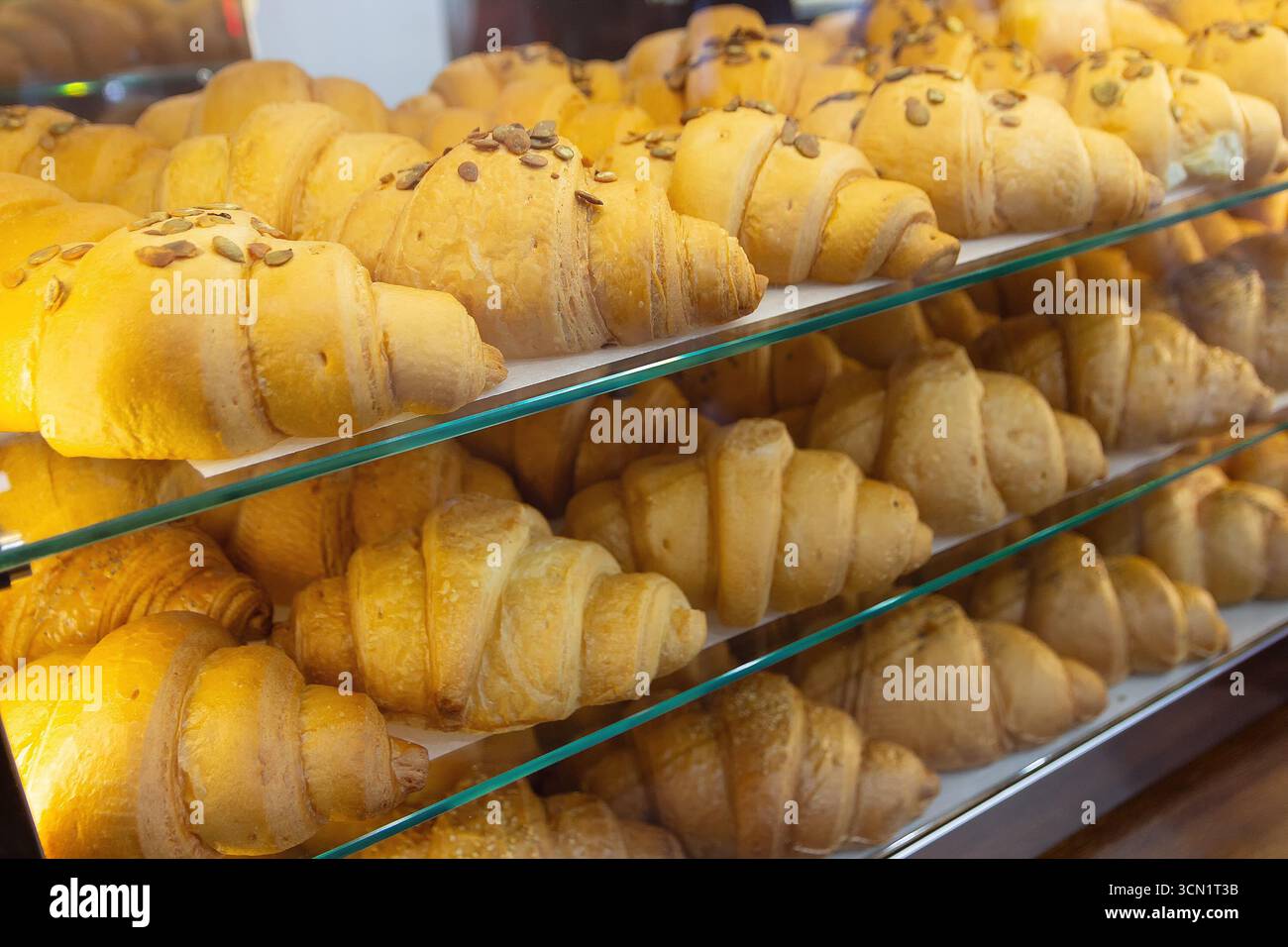Fresh delicious croissants on display in the bakery. Food Stock Photo