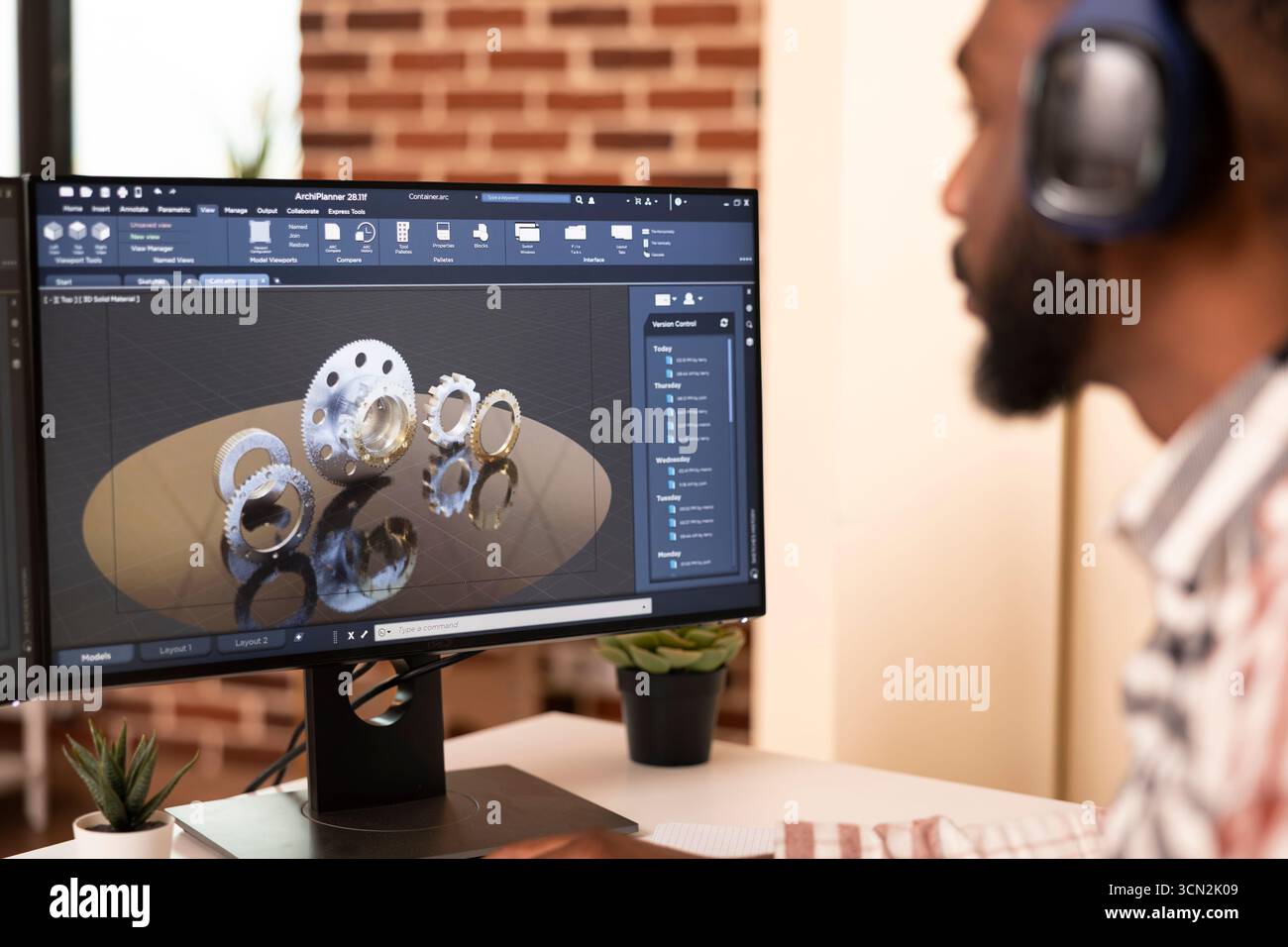 African american male engineer seated at home desk, developing digital prototypes using computer aided design tools. Creative developer focused on construction innovation and 3D modeling workflow. Stock Photo