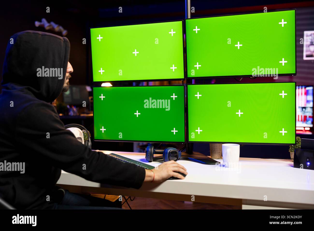 Man coding on isolated screen PC displays, creating stealth malware that evades security. Hacker using mockup multi monitor setup to make script hiding malicious code from detection systems Stock Photo