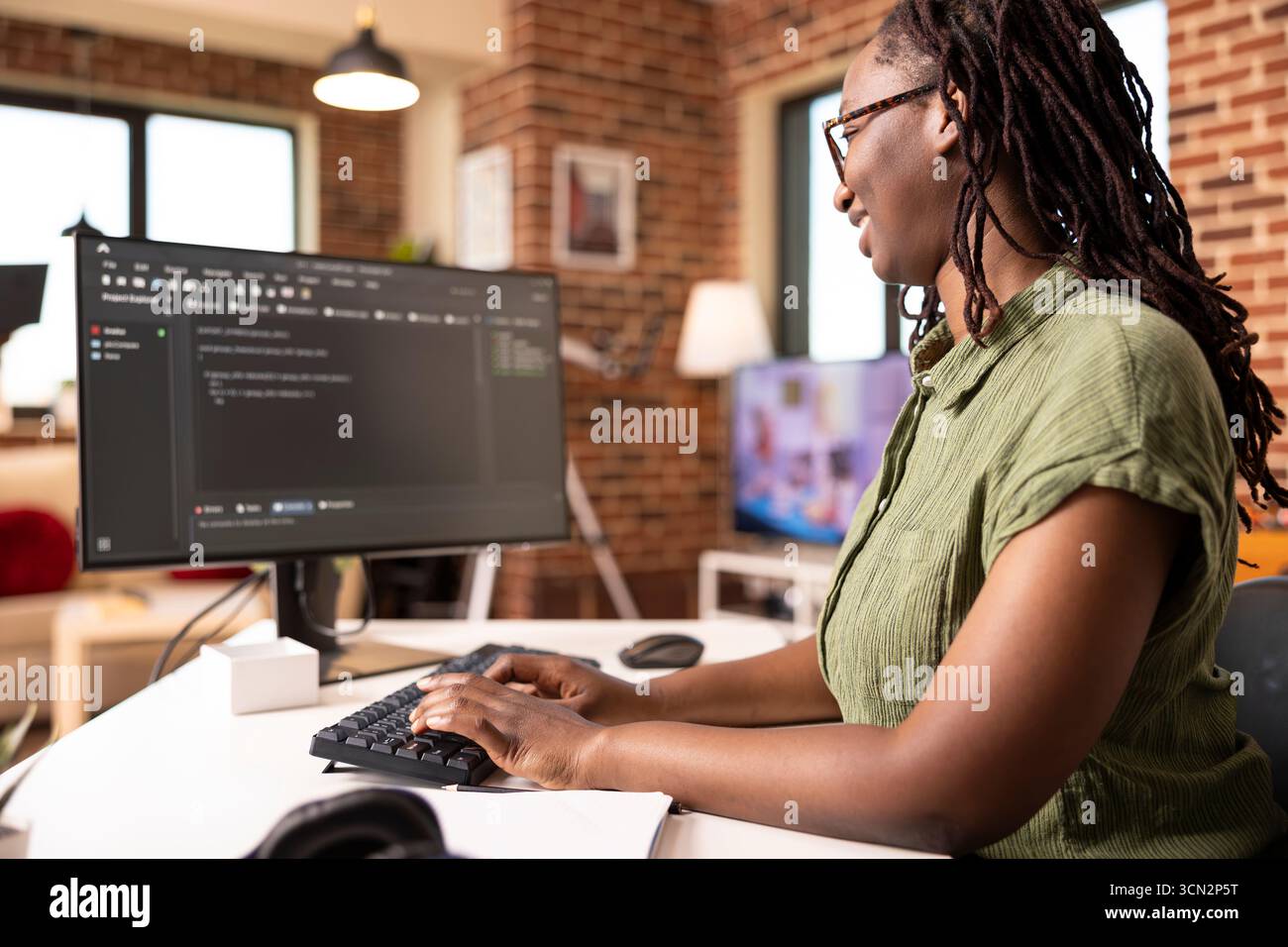 Black female software developer codes securely from home office, using computer to review programming scripts. African american IT freelancer working on tech solutions in modern apartment. Stock Photo