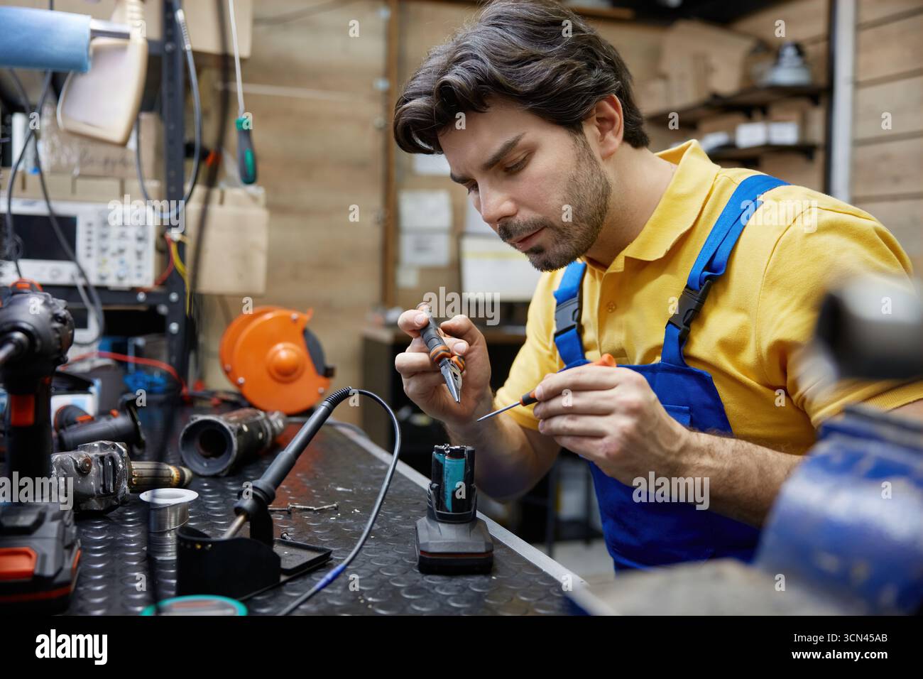 A skilled worker works on an electronic device Stock Photo