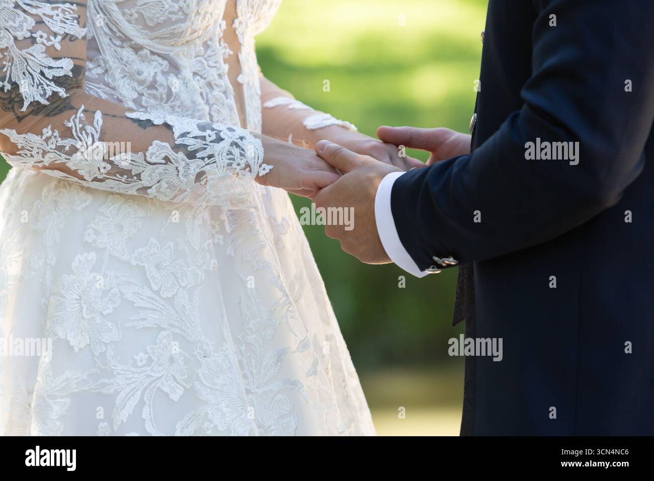 Bride and groom holding hands during wedding ceremony, celebrating their love and commitment Stock Photo