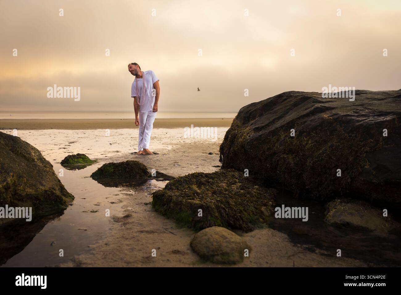 Man wearing white dancing in the beach on Cape Cod during the pi Stock Photo