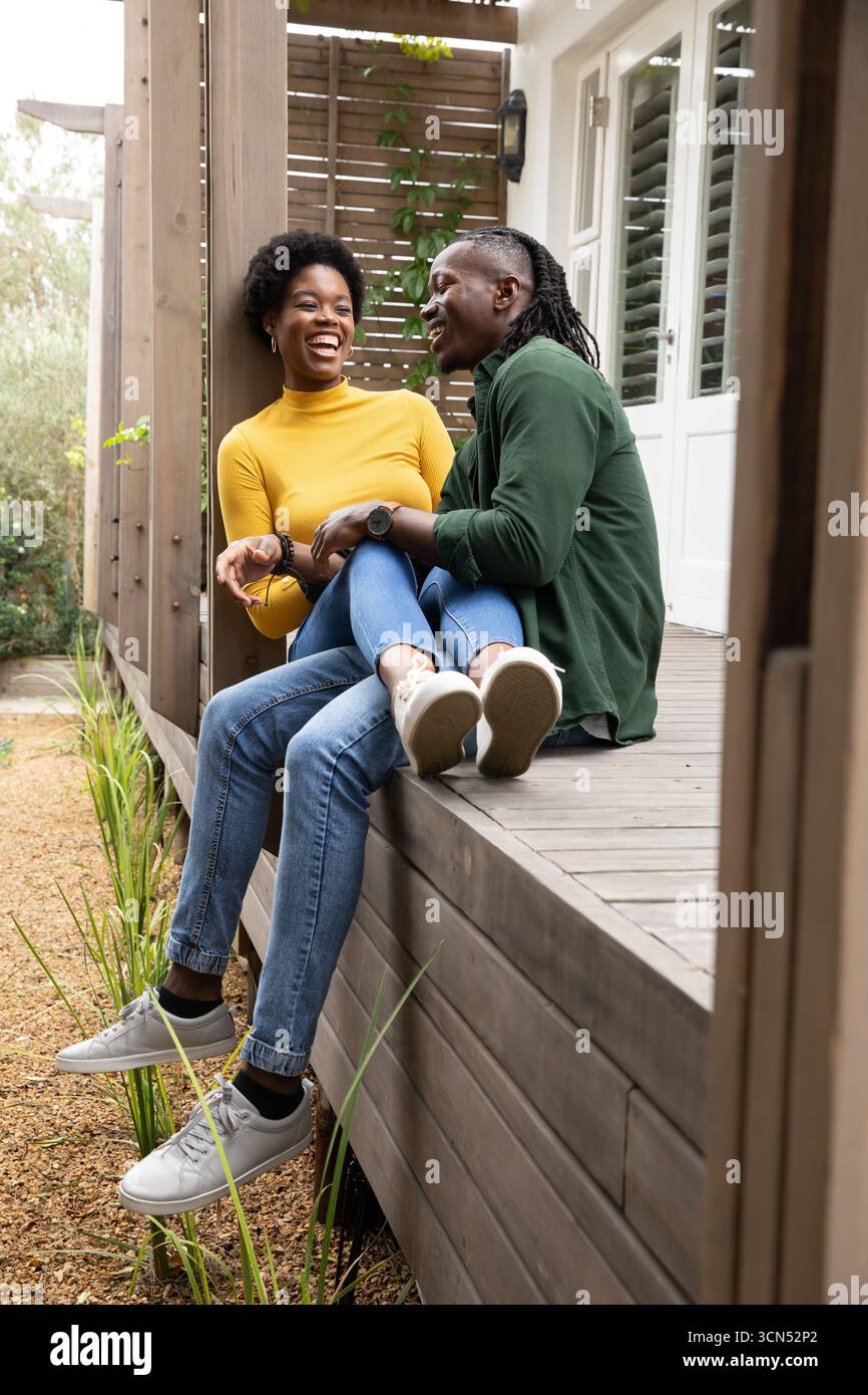 African American Couple Sitting On Porch Bench Laughing Near Privacy african-american-couple-sitting-on-porch-bench-laughing-near-privacy