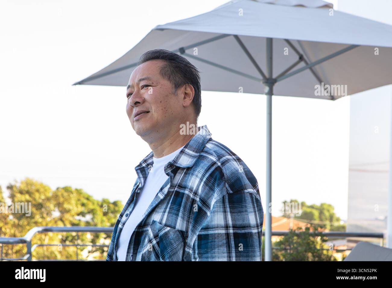 People Standing Behind Railing Chinese man standing on balcony behind railing under umbrella gazing at ...