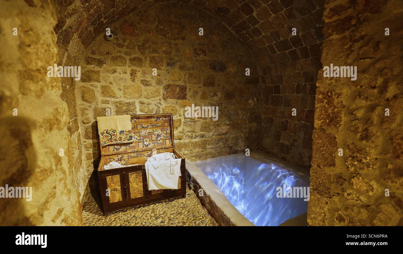 A stone room with an illuminated immersion bath for ritual purification ...