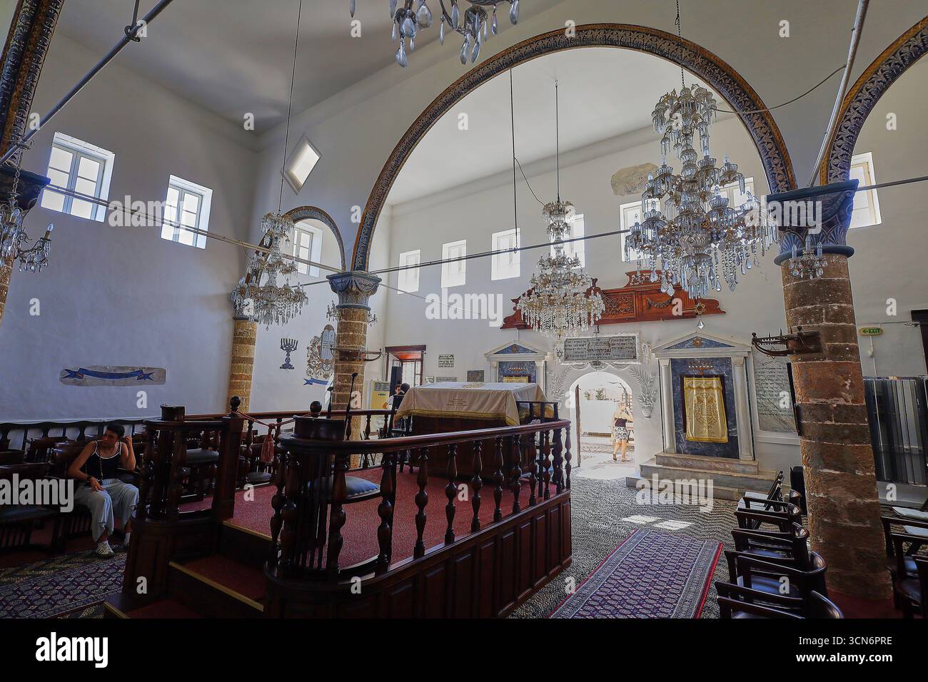 Interior view of a synagogue with chandeliers and decorative arches ...