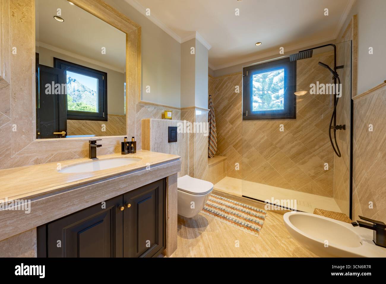 an image of a marble stone bathroom with standing shower in mediterranean home Stock Photo