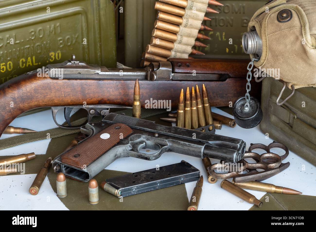 Gun and a box of bullets are on a table. The gun is a Colt 45. There ...