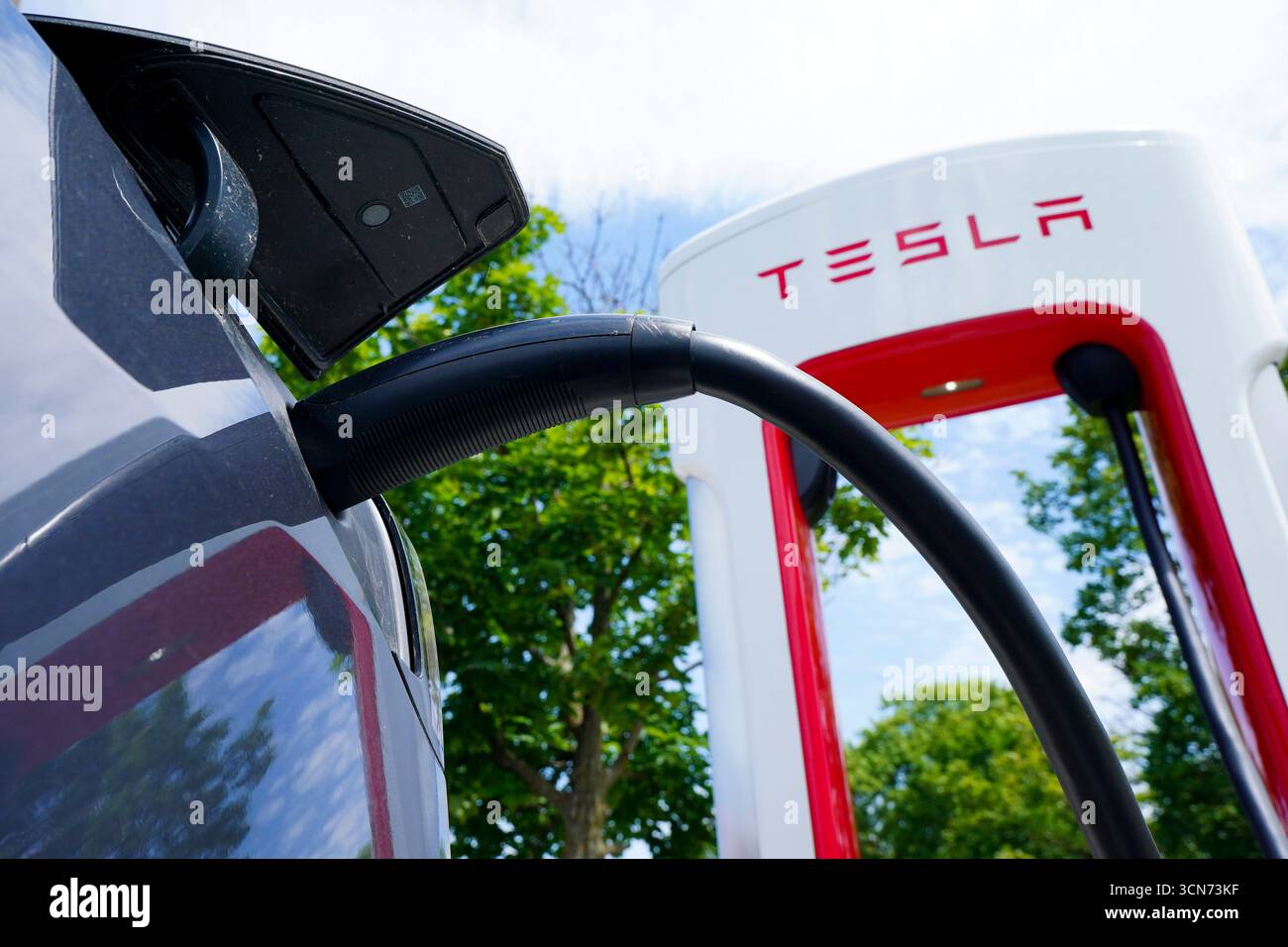 An electric vehicle is charged at a Tesla charging station in Ottawa on ...