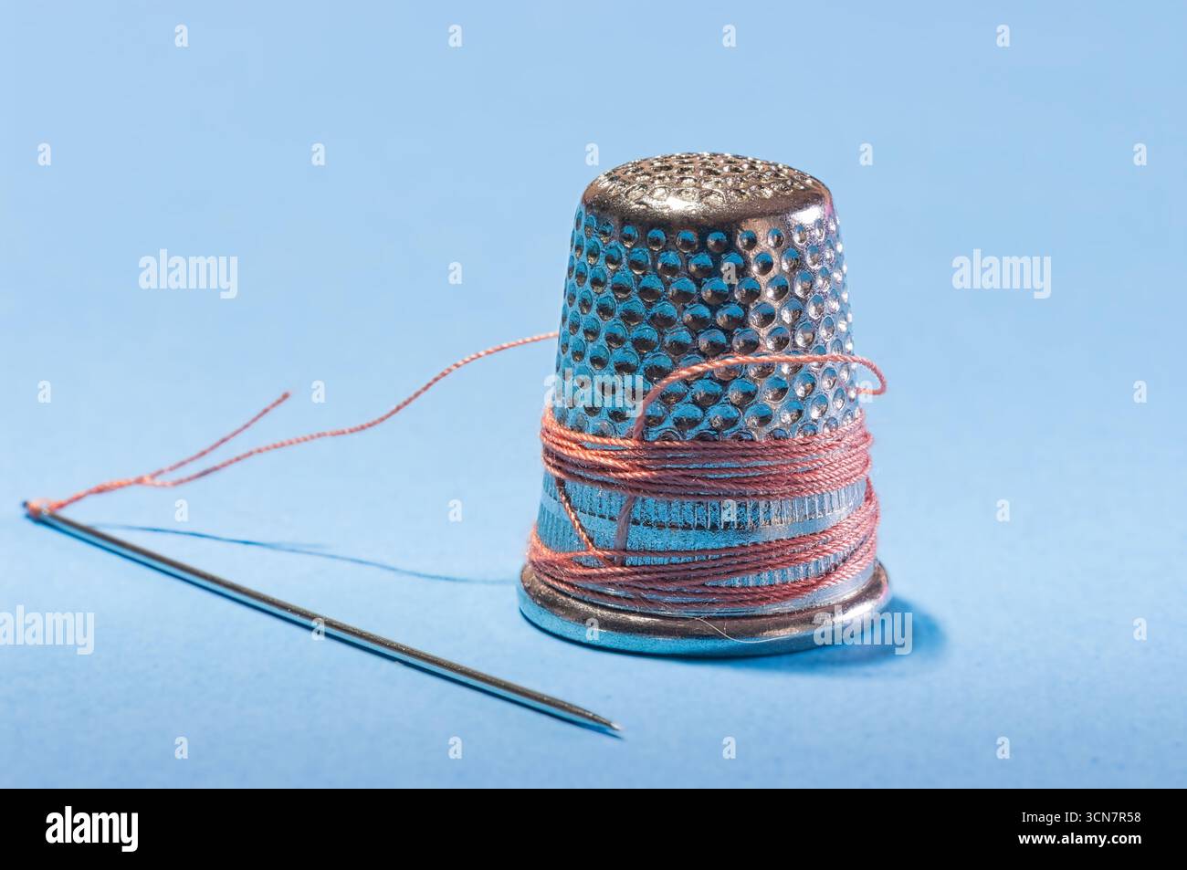 Sewing needles, thread, scissors, and thimbles. Stock Photo