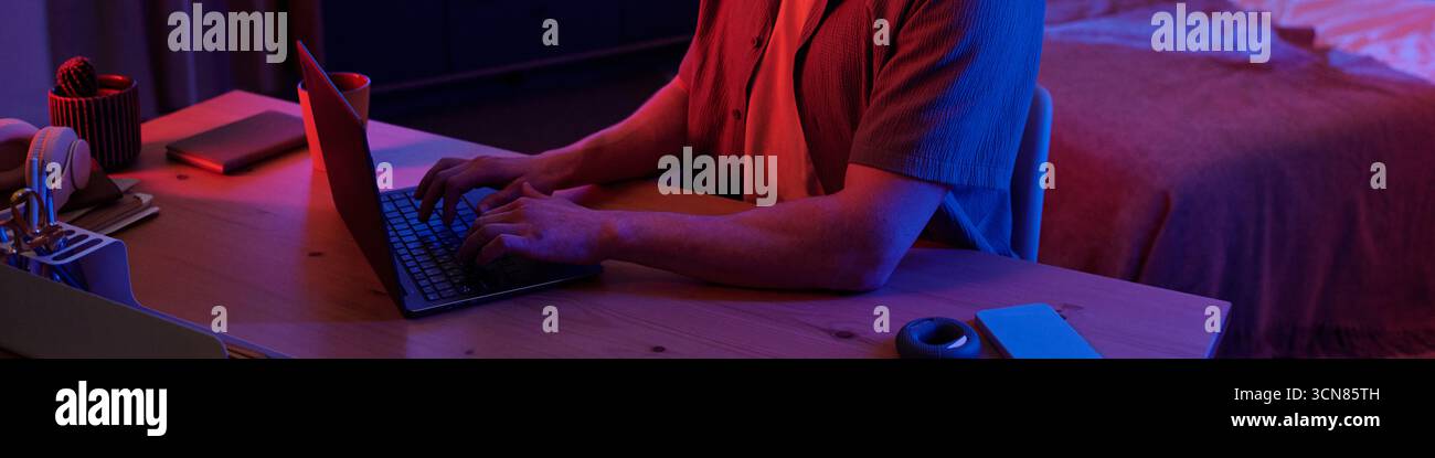 Man Using Laptop Computer While Working Late at Night Stock Photo
