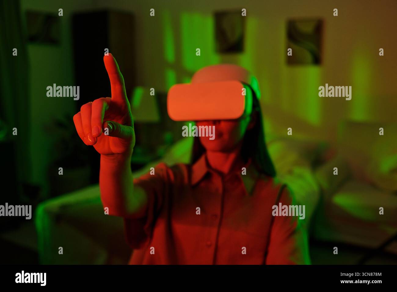 Woman Using Virtual Reality Headset Interacting Indoors Stock Photo