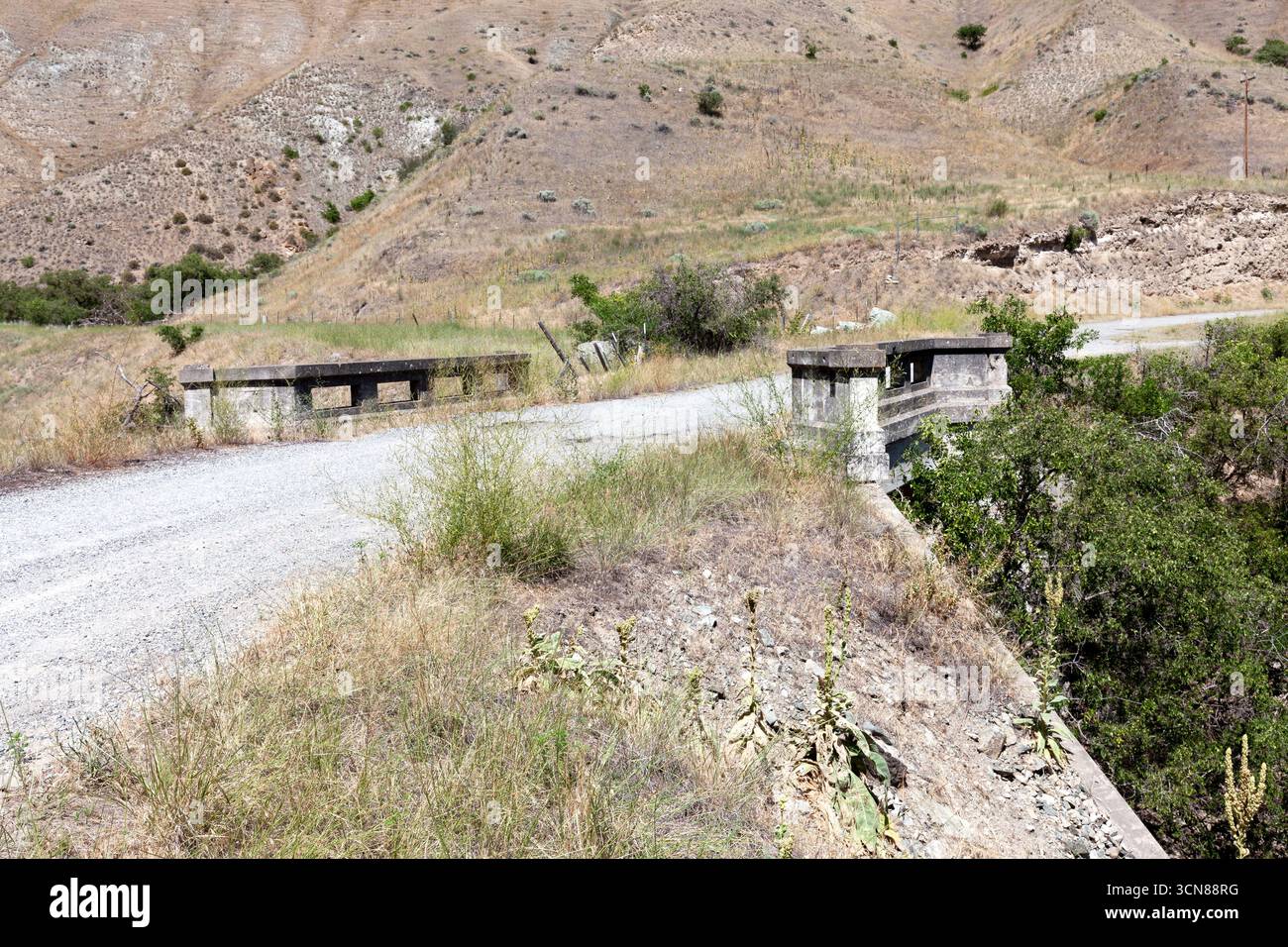 1920's era Concrete railings remain over a culvert along an abandoned section of US 95 roadbed along the Salmon River south of White Bird, Idaho. Stock Photo
