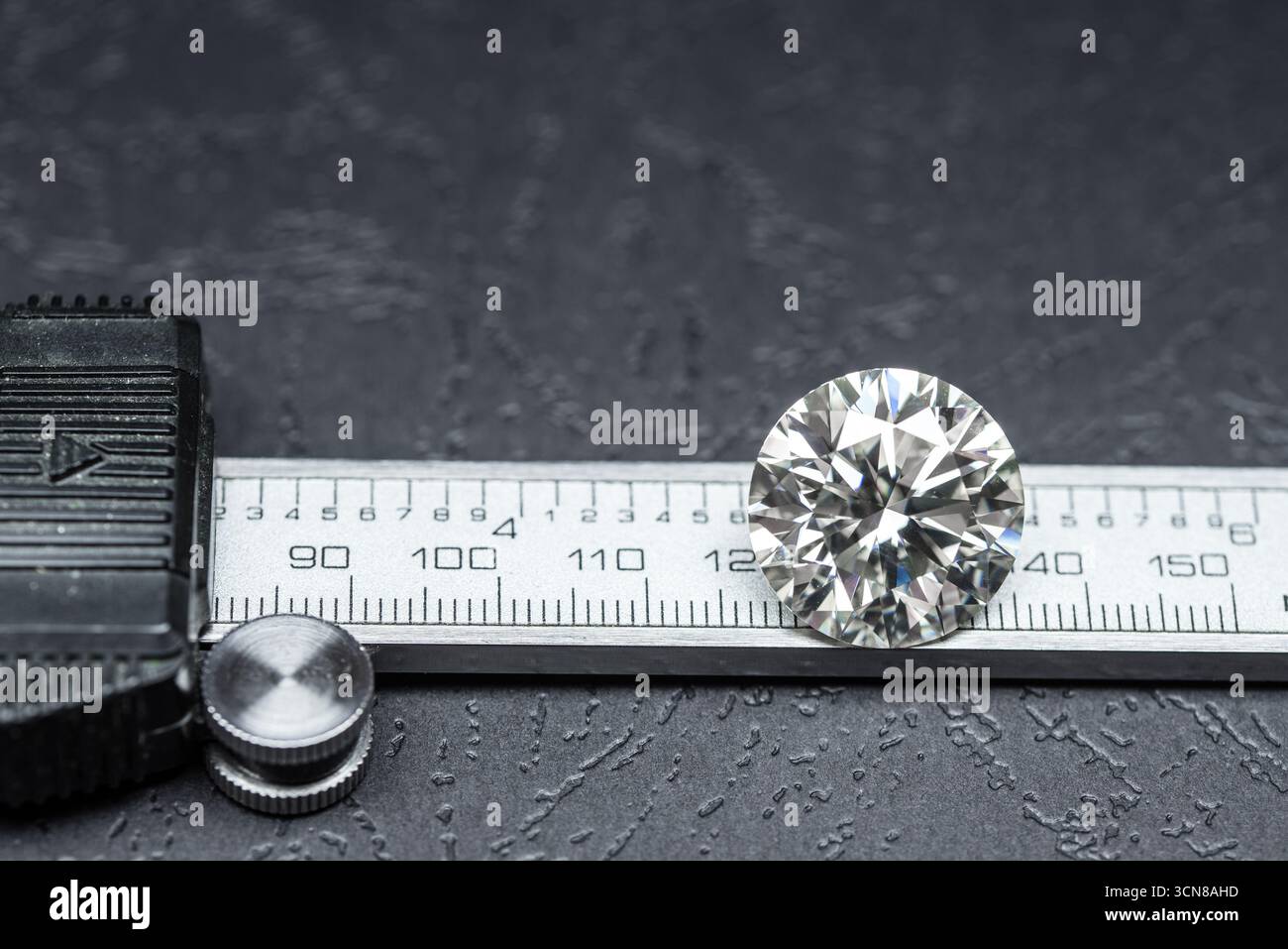 A diamond is on a ruler and the ruler is black. The diamond is on the ...