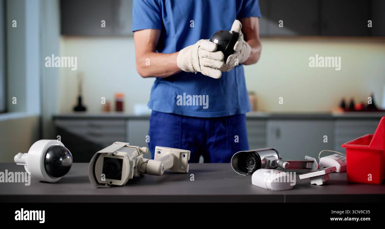Skilled Technician Setting Up Surveillance Camera For Building Security System. Stock Photo