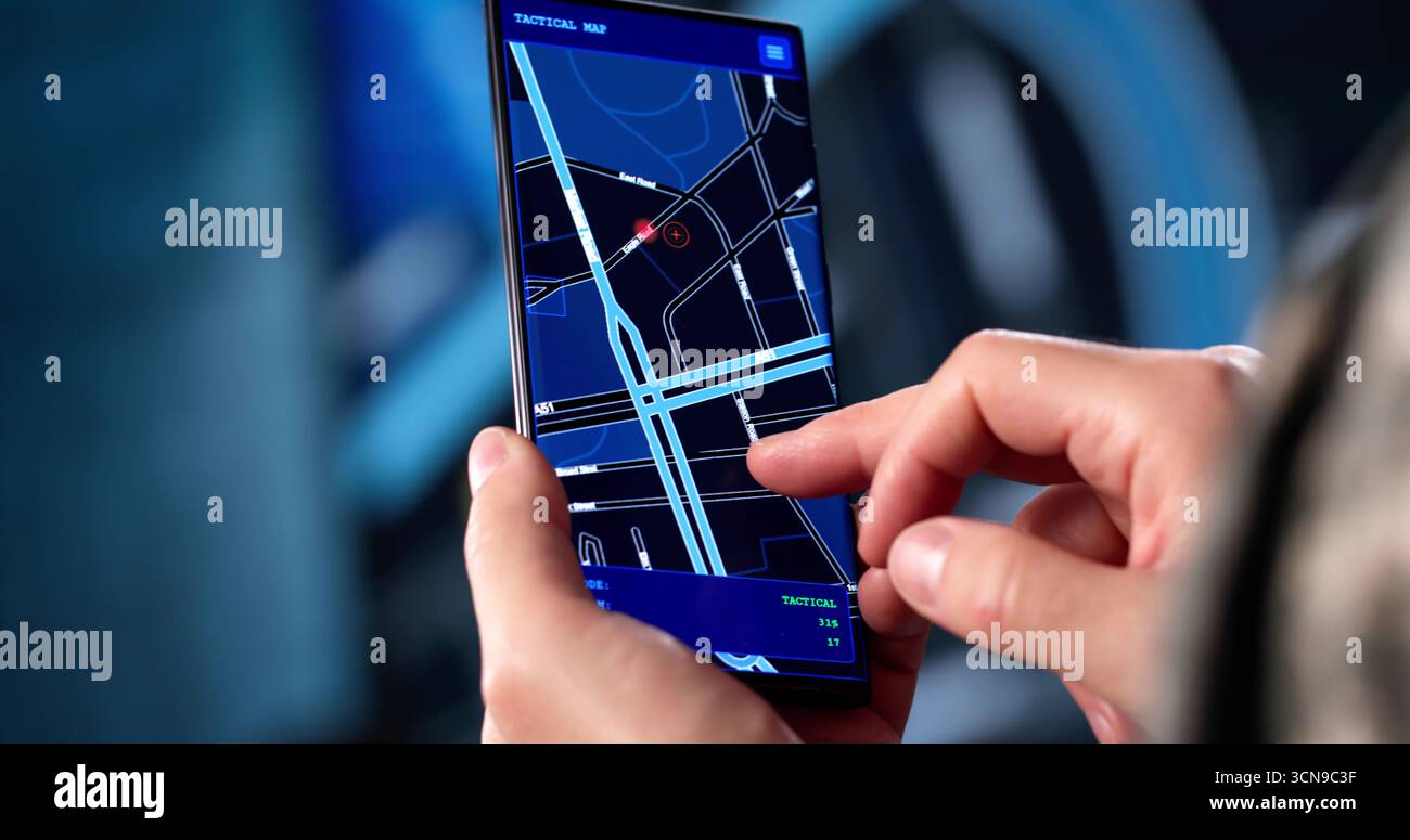 Soldier In Camouflage Uniform Navigates Military Position Using GPS Map. Stock Photo