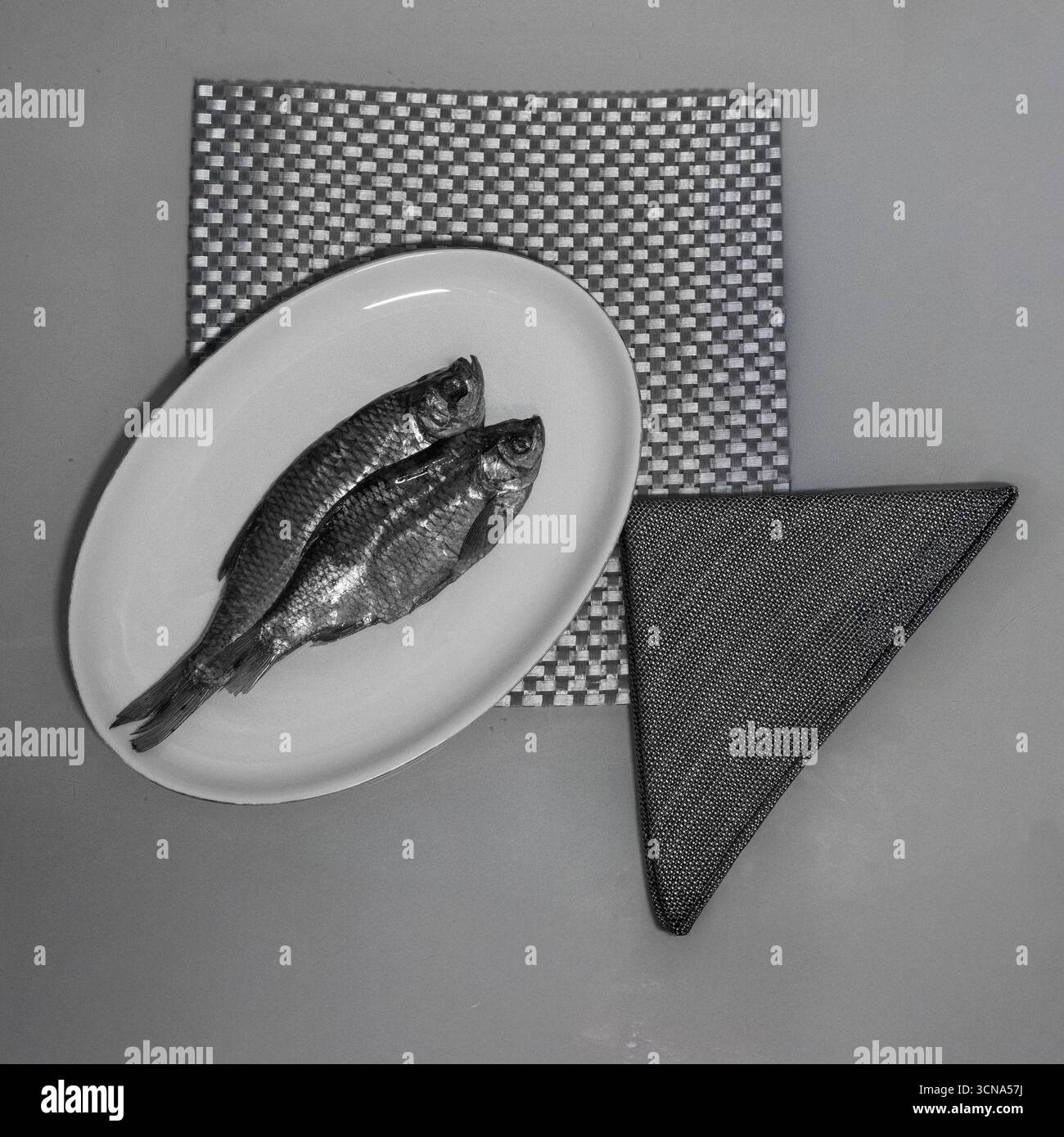 Dried Fish on Plate with Geometric Background Monochrome. Stock Photo