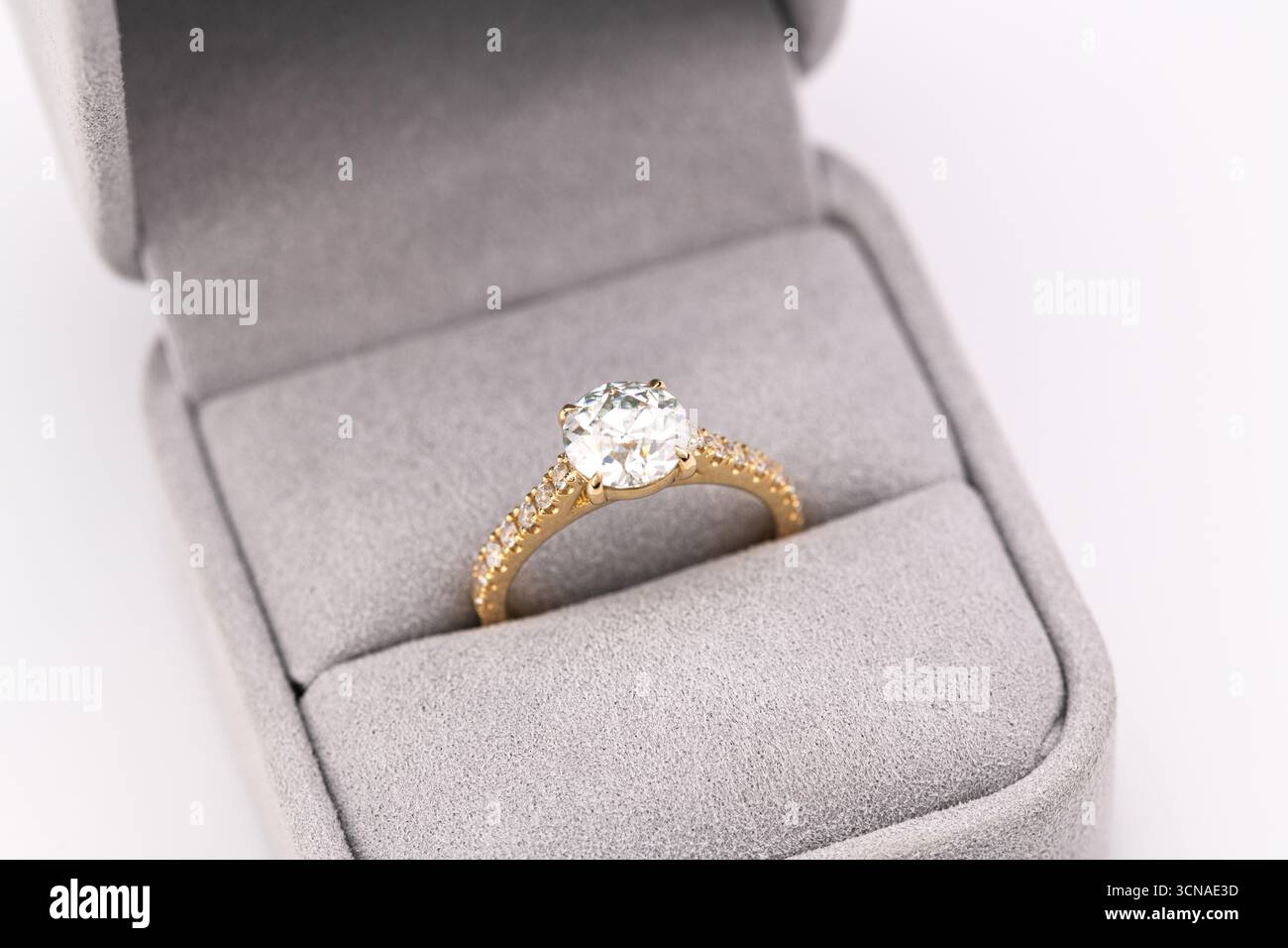 A gold and diamond ring is in a box. The ring is a beautiful and ...