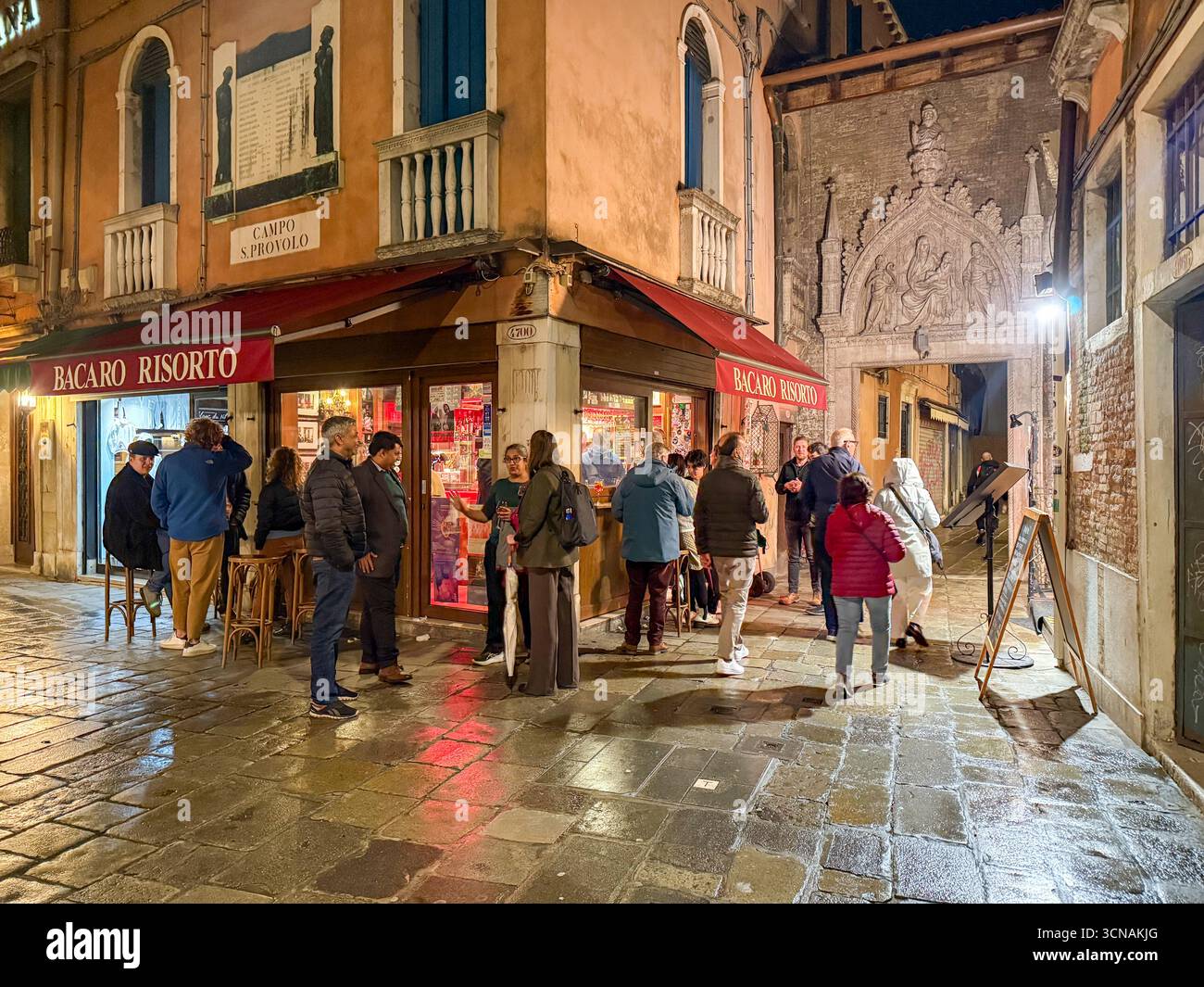 Night view of a typical Venetian bacaro (wine bar) in Campo San Provolo, in the sestiere of Castello, Venice, Veneto, Italy - Smartphone Captured Stock Image
