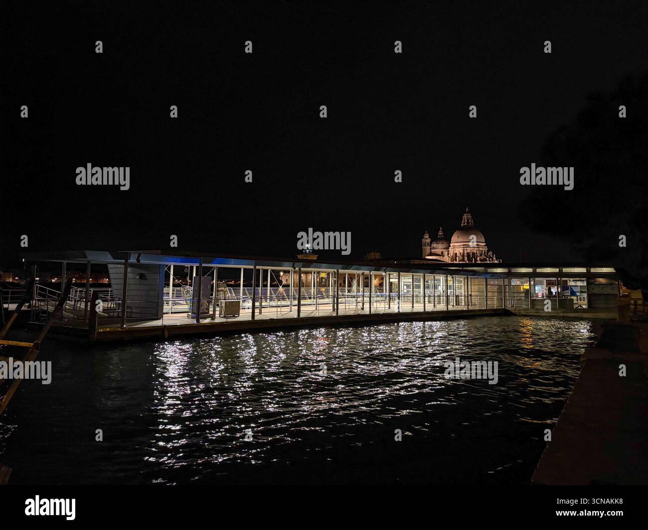 Night view of the Grand Canal with San Marco - Giardinetti water bus stop, Punta della Dogana and Basilica of Santa Maria della Salute, Venice, Italy - Smartphone Captured Stock Image