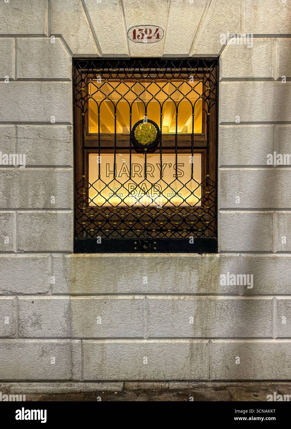 Lighted window of the Harry's Bar, historic bar-restaurant founded in 1931 by Giuseppe Cipriani and declared national heritage, Venice, Veneto, Italy - Smartphone Captured Stock Image